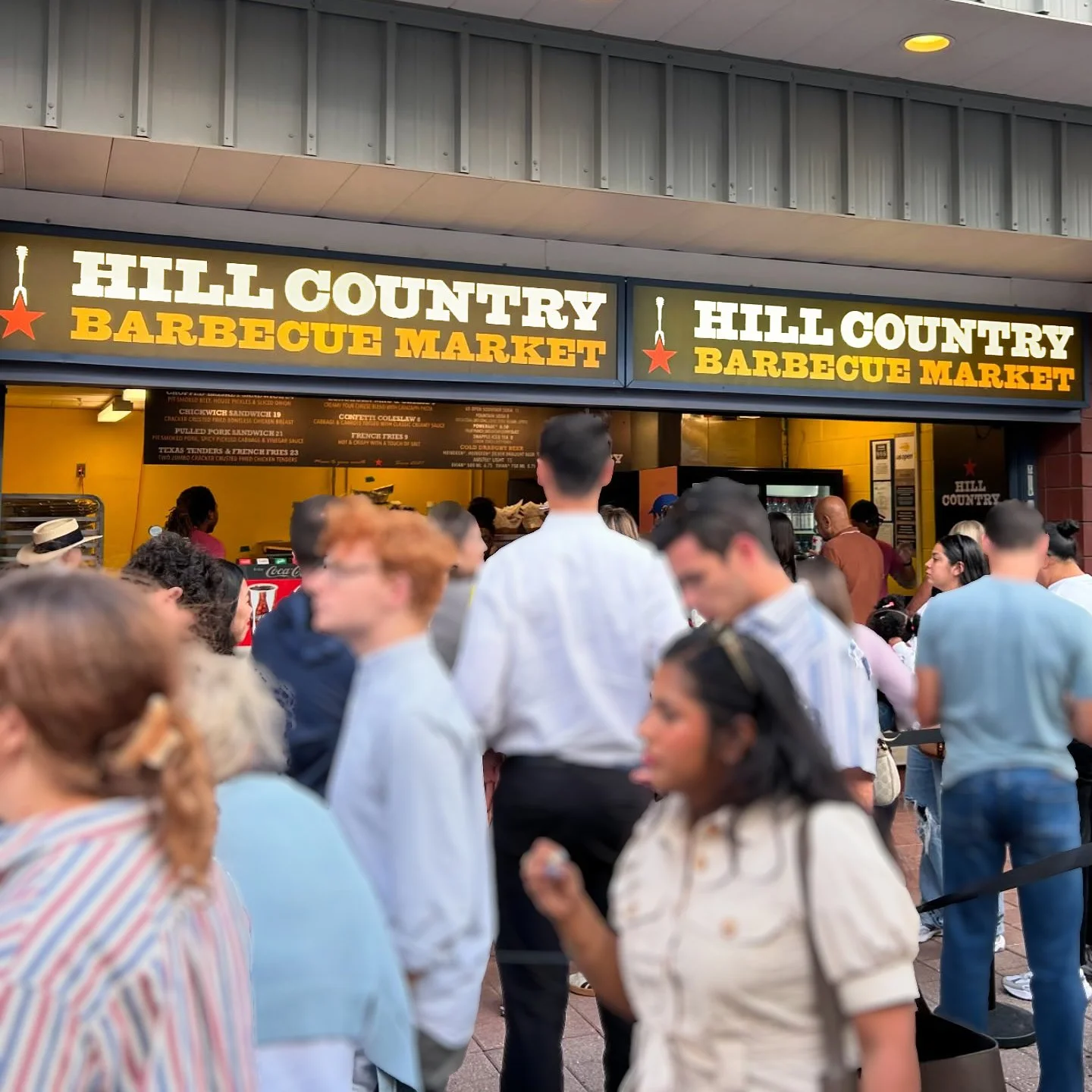 Customers gathered beneath Hill Country Barbecue Market signage at the US Open concession.