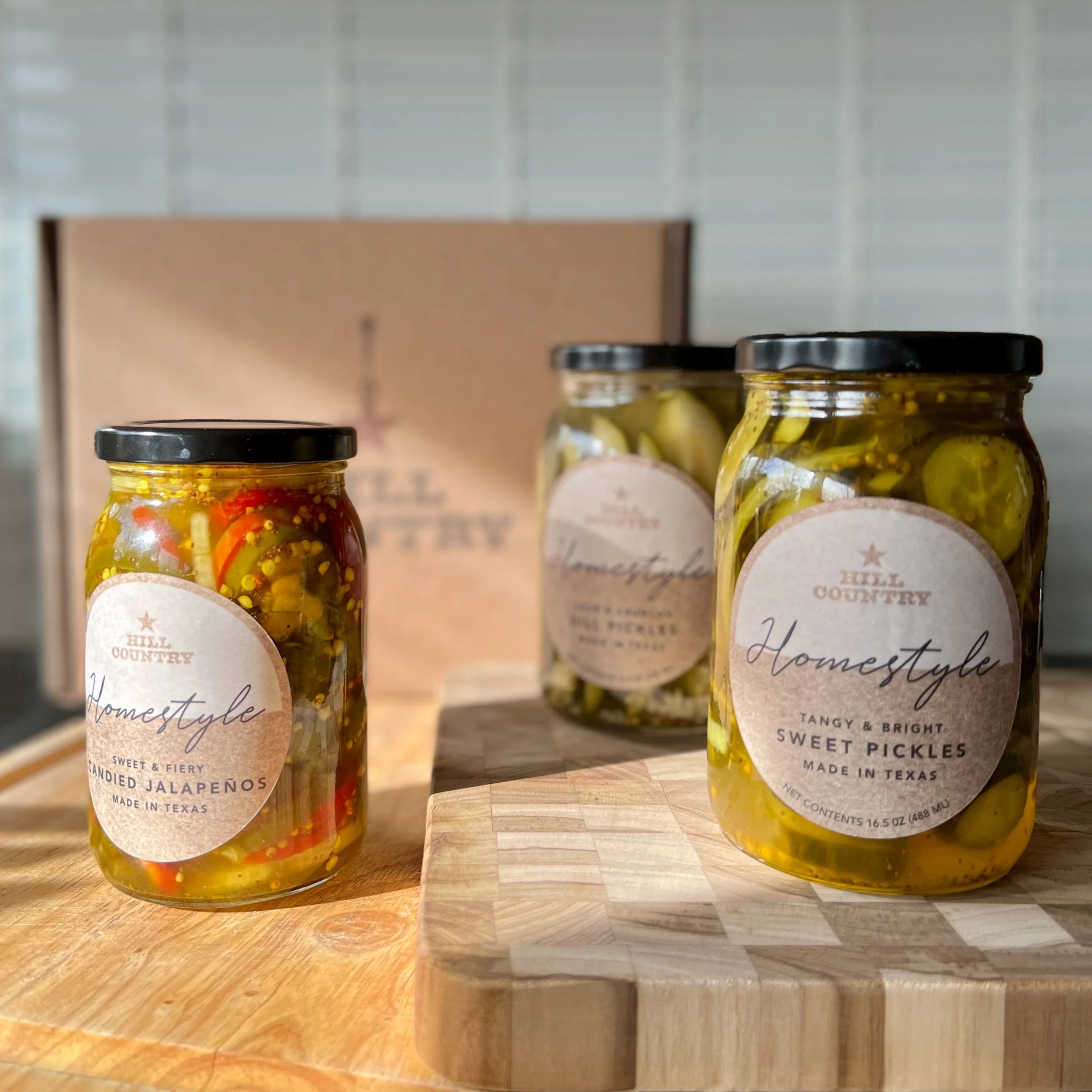 Finished Hill Country Homestyle jars on a kitchen counter beside a branded shipping box.