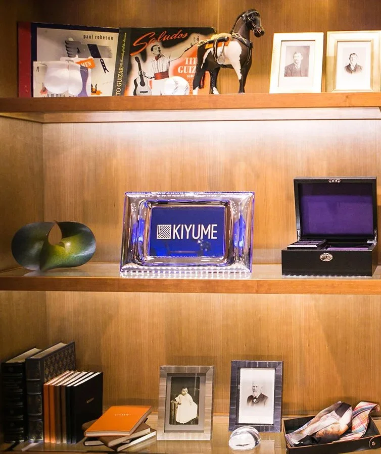 Kiyume retail display with books, framed photographs and collectible objects arranged on wooden shelves.