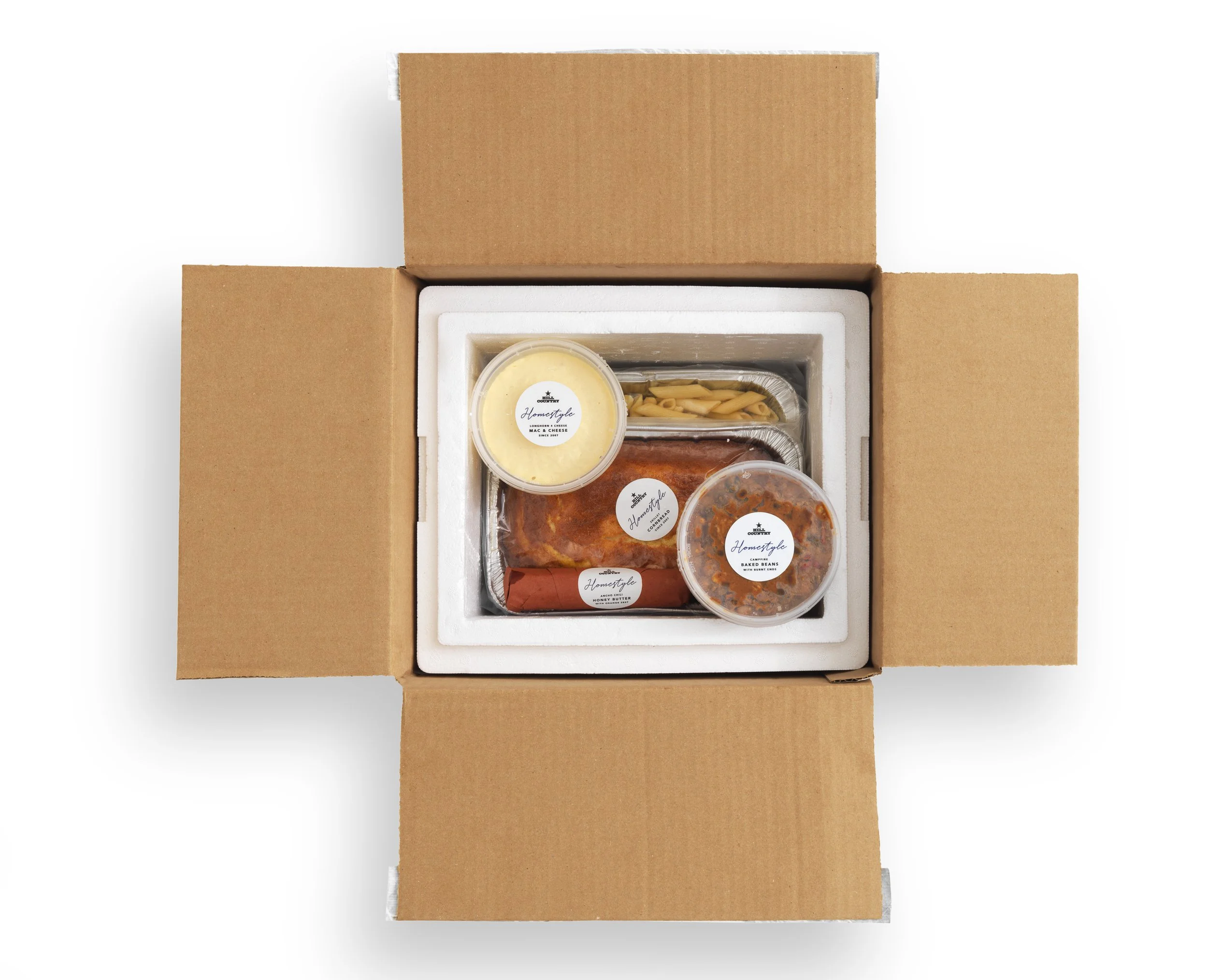Open Hill Country Homestyle insulated box containing prepared food trays and labeled tubs.
