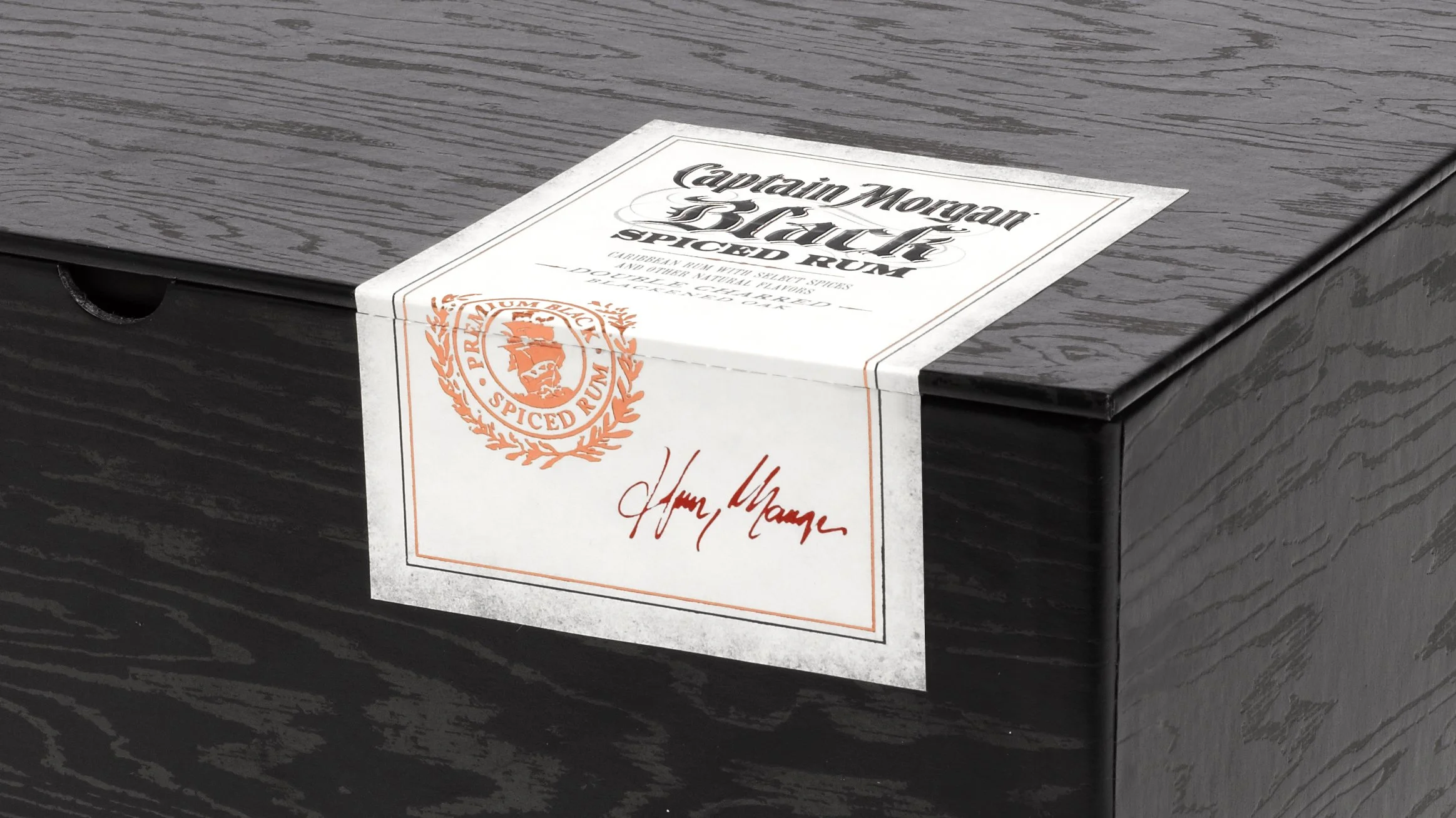 Close-up of the Captain Morgan Black label sealing the black wood-grain presentation box.