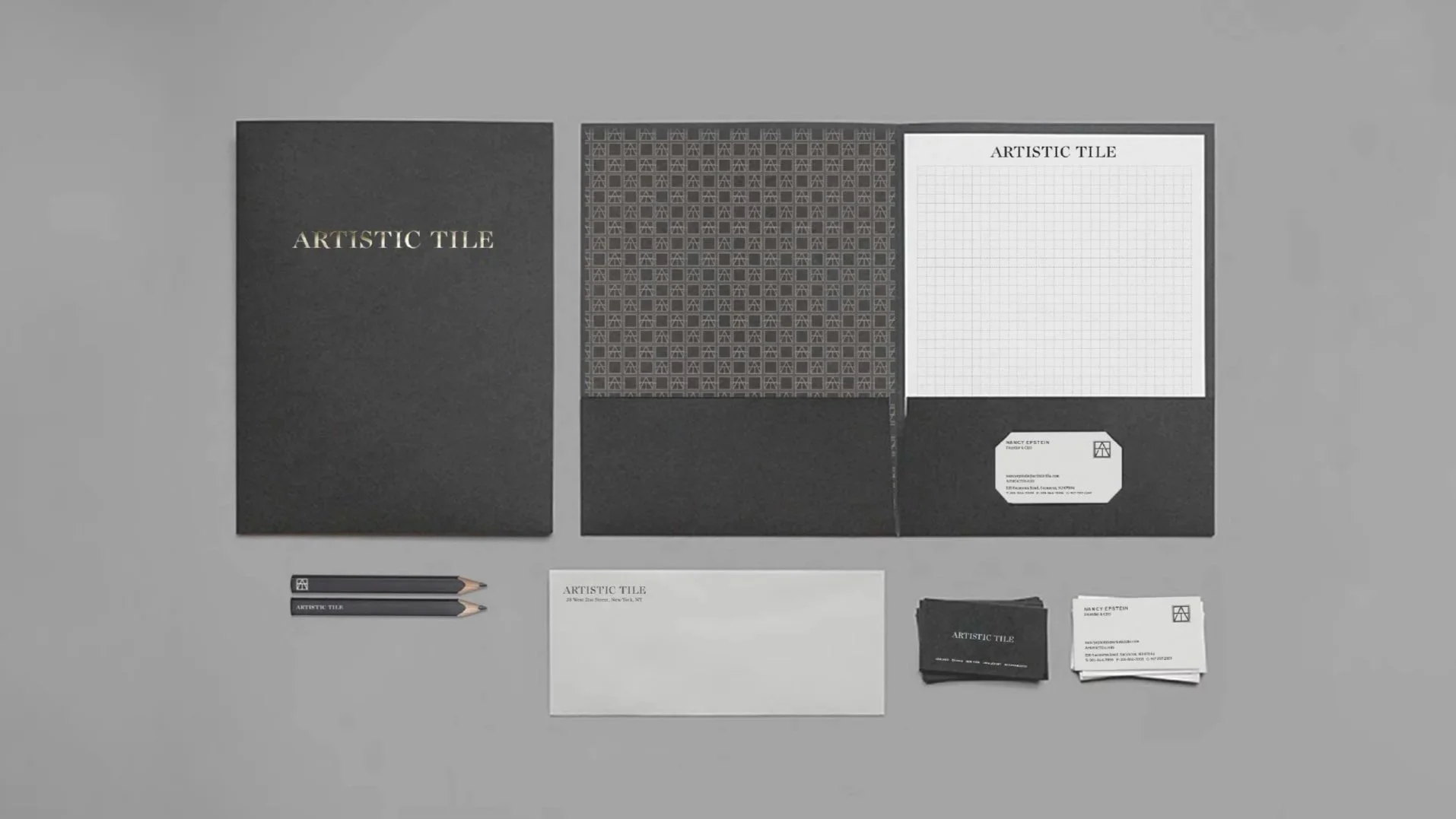 Artistic Tile stationery system with presentation folders, a notepad, business cards, pencils and an envelope.