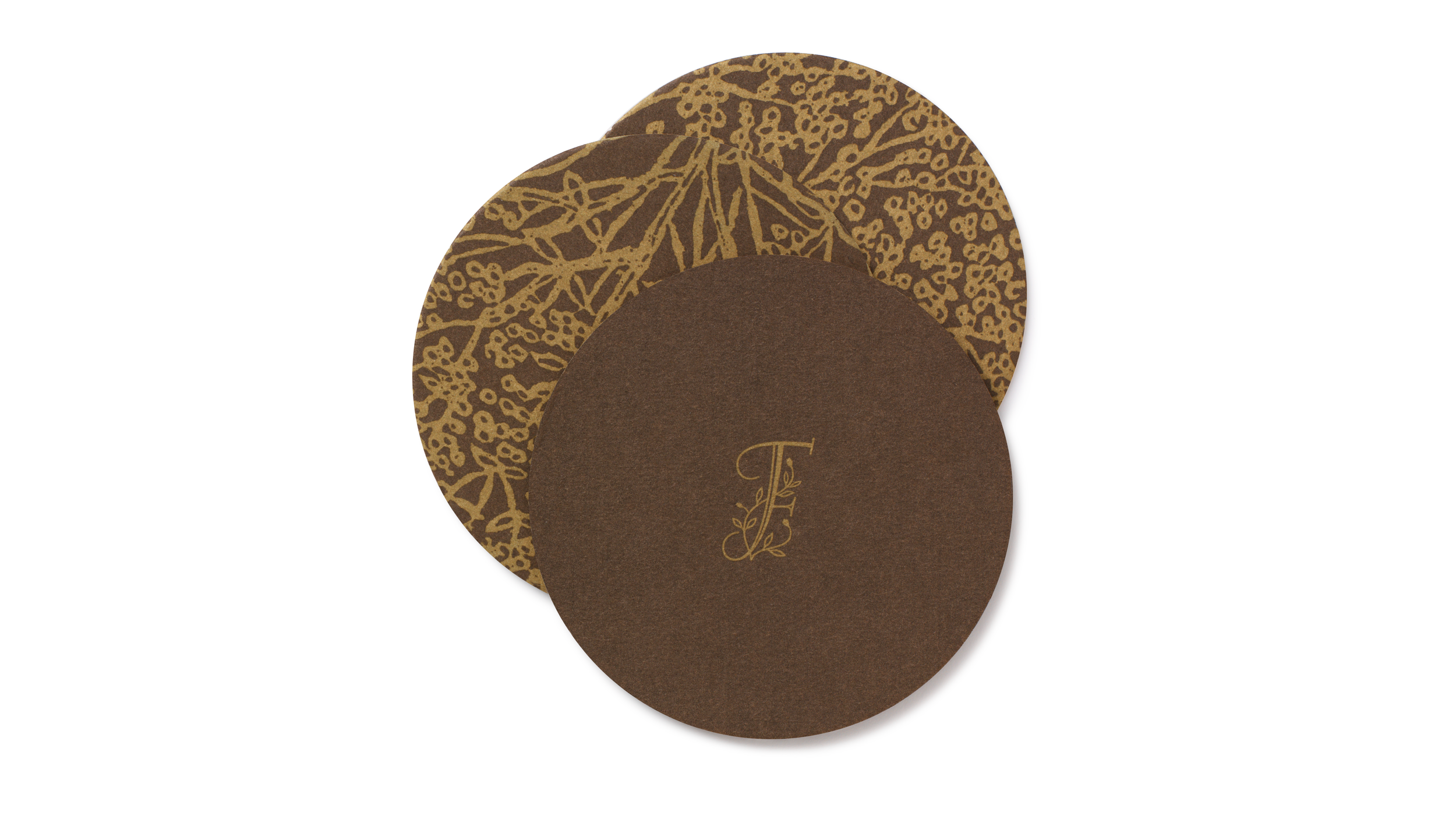 Round Ai Fiori coasters featuring a gold floral pattern and monogram on brown.