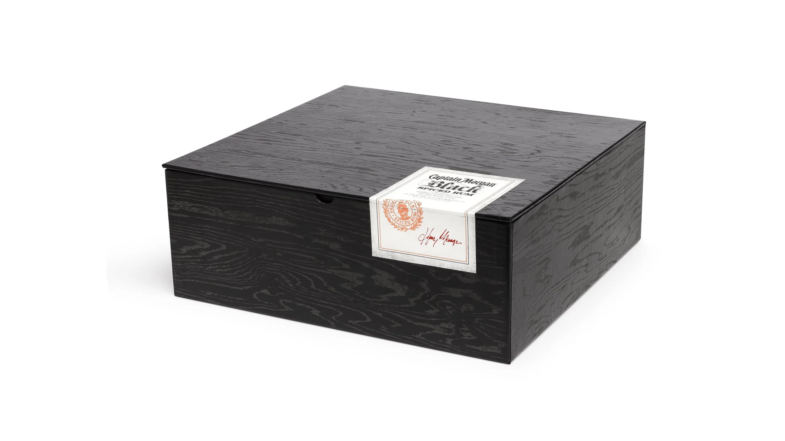 Closed Captain Morgan Black presentation box with black wood grain and a white branded seal.