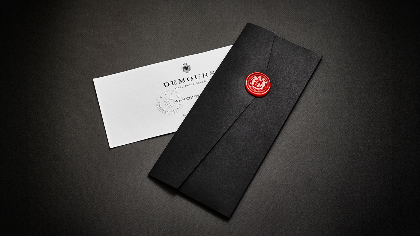 Demours Coffee gift certificate with a black envelope and red wax seal.