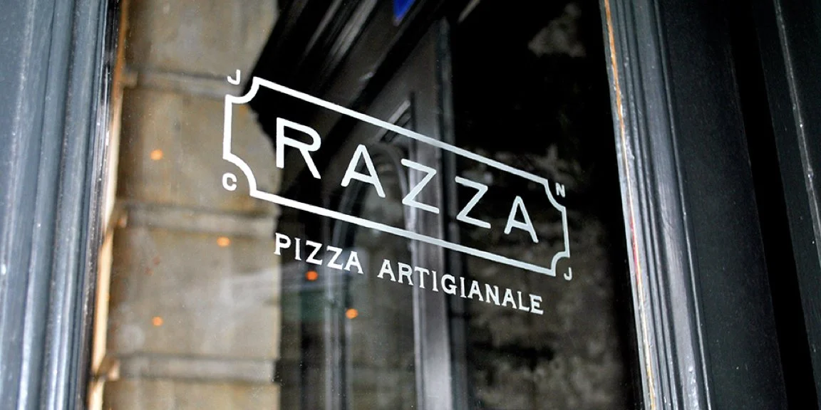 White Razza Pizza Artigianale logo applied to the restaurant’s glass entrance door.
