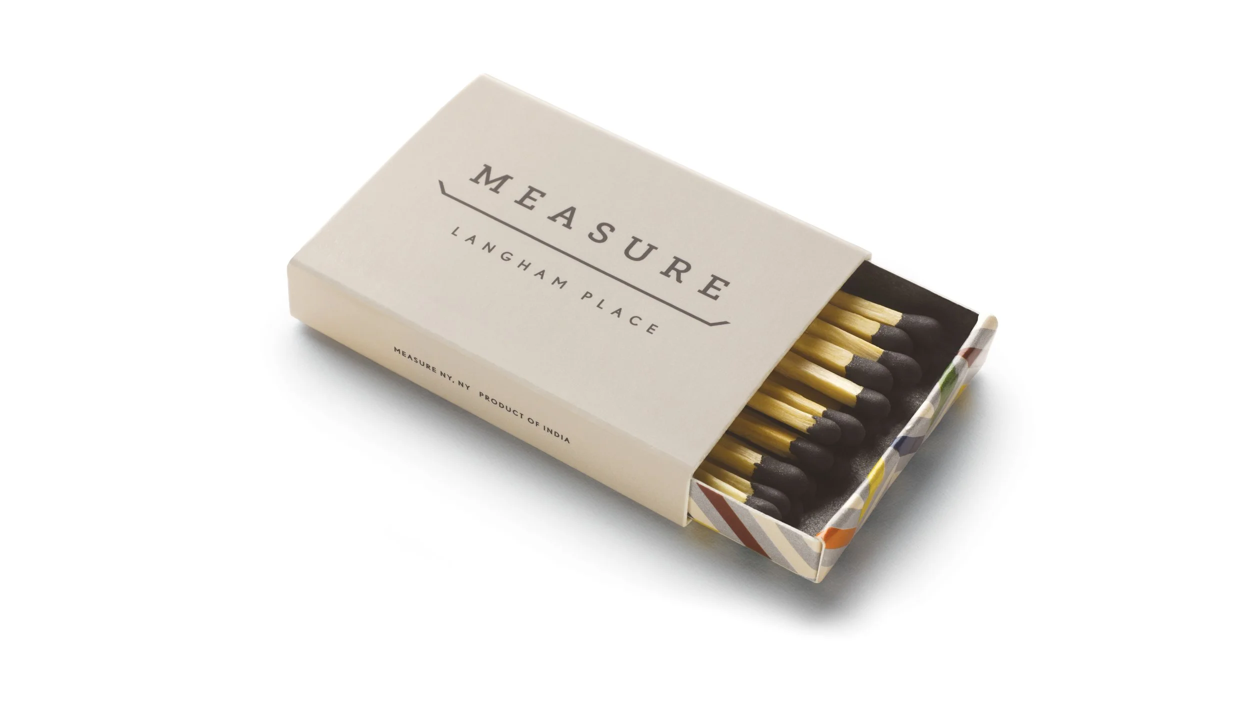 Open Measure Langham Place matchbox with a cream sleeve and multicolored herringbone tray.