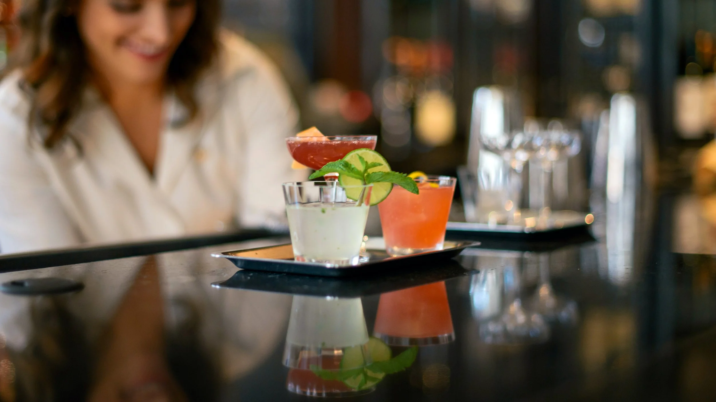 Colorful cocktails served on a tray at Measure’s reflective bar.