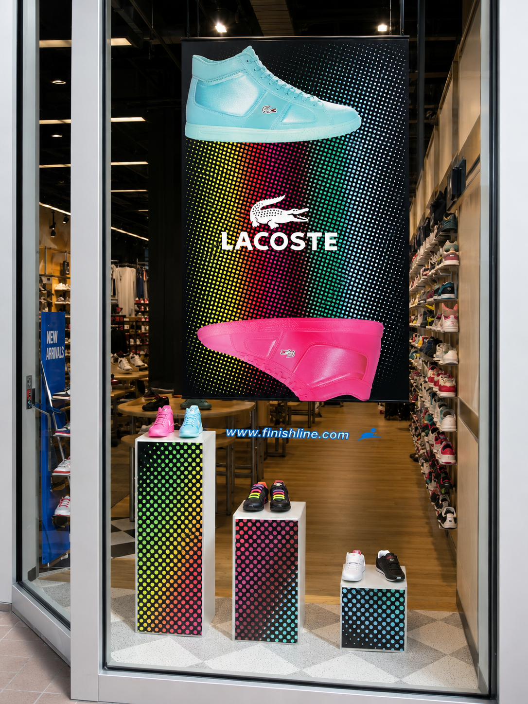Lacoste window display at Finish Line with cyan and pink sneaker graphics and matching dotted product pedestals.