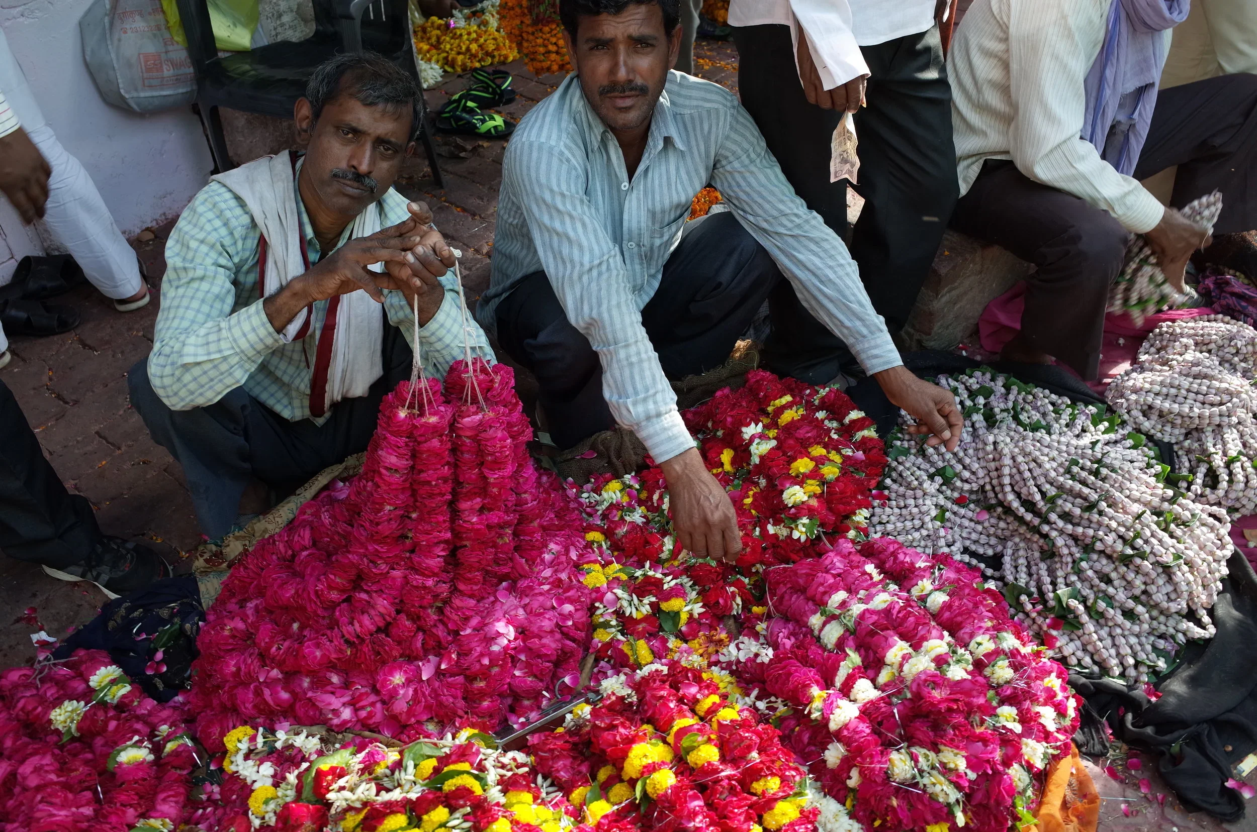 Men selling flowers used for funerals at a market in Varanasi, India.