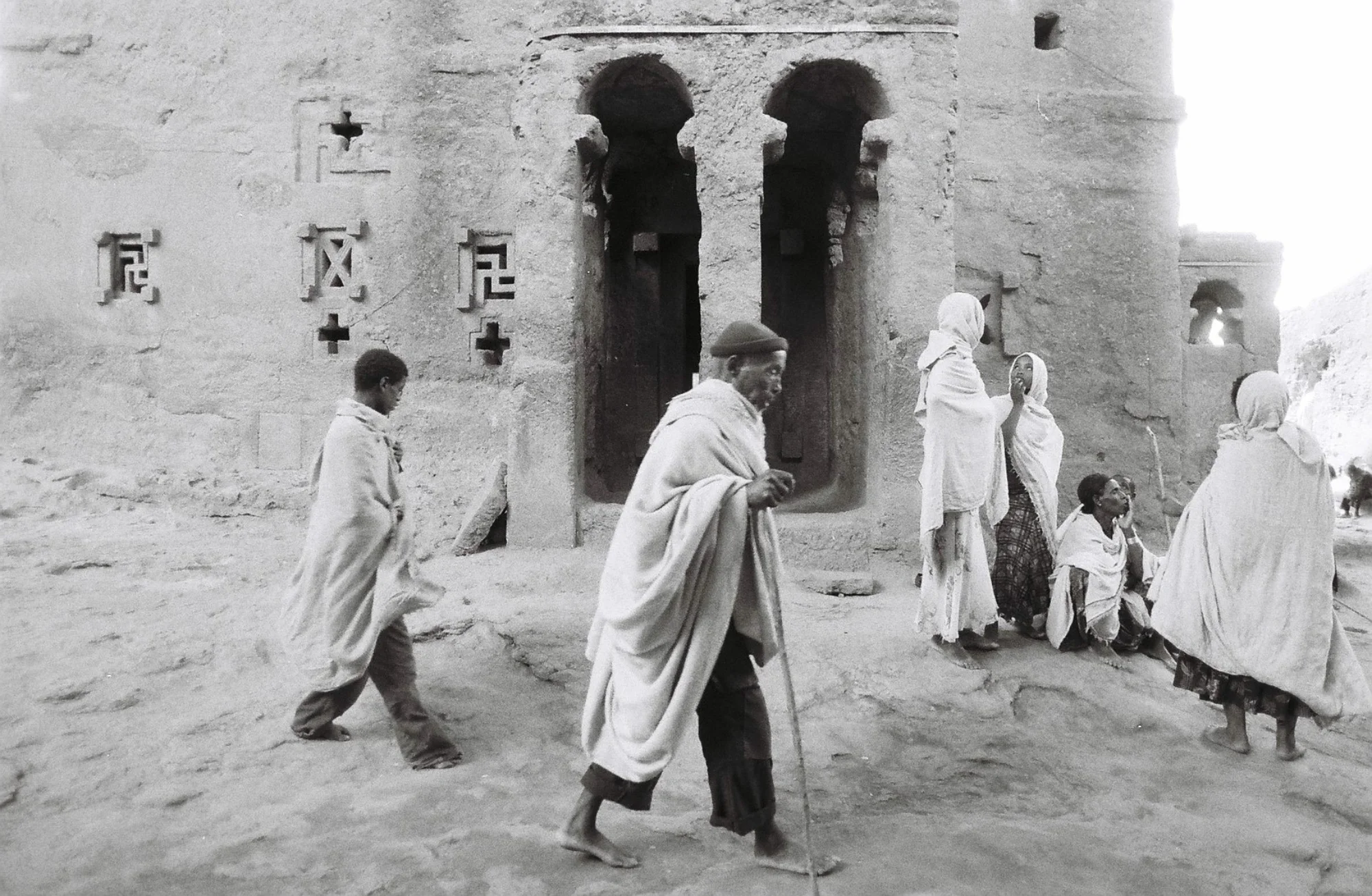Pilgrims shrouded in traditional white woven cotton, walk barefoot great distances to pray among the sacred Churches during Orthodox Christmas. Many sleep on the ground outside entrance ways, or share camps in the surrounding area.