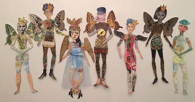 A collection of seven mixed-media art dolls or figures with butterfly-inspired wings, each with unique clothing, hairstyles, and accessories, displayed against a plain background.