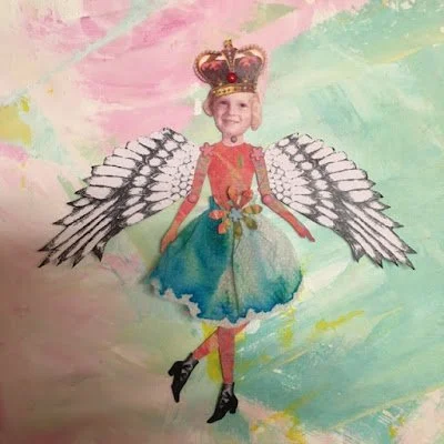 Child dressed as a fairy with a crown, wings, colorful dress, and holding a flower, standing in front of a pastel-colored painted background.