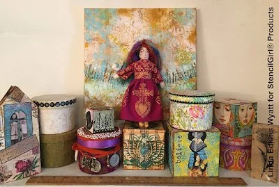 Display of colorful decorative boxes and a doll dressed in a red and gold outfit on a shelf.