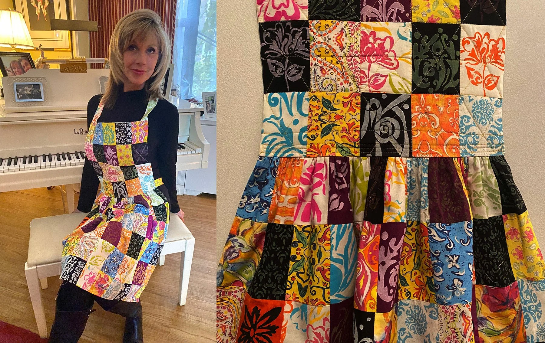 A woman sitting on a stool next to a white piano, wearing a colorful patchwork quilt dress made of various patterned fabric squares. The quilt dress covers her entire body, with a black top and black pants underneath.
