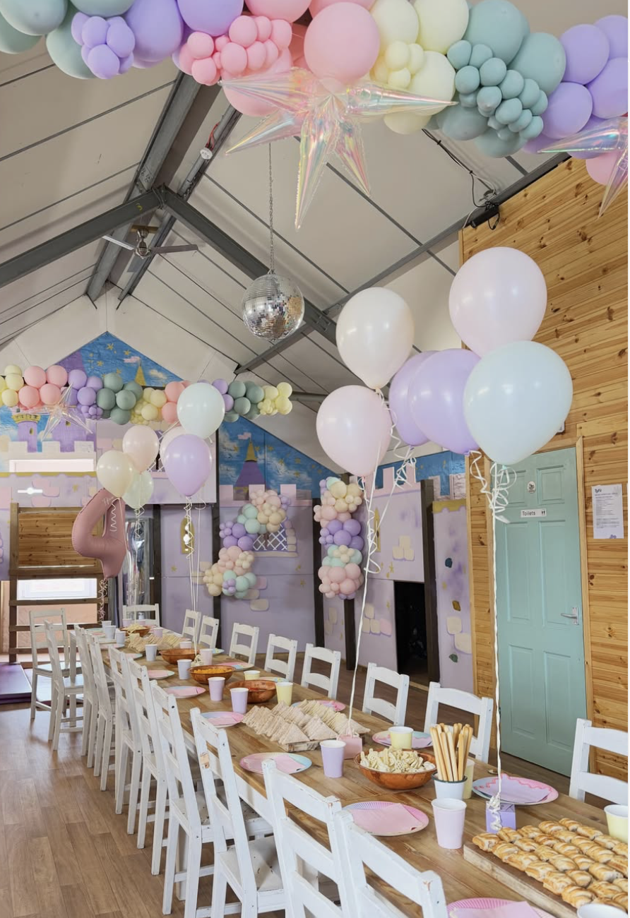 Party table setup with pastel coloured tableware and decorations for a private children's birthday party.