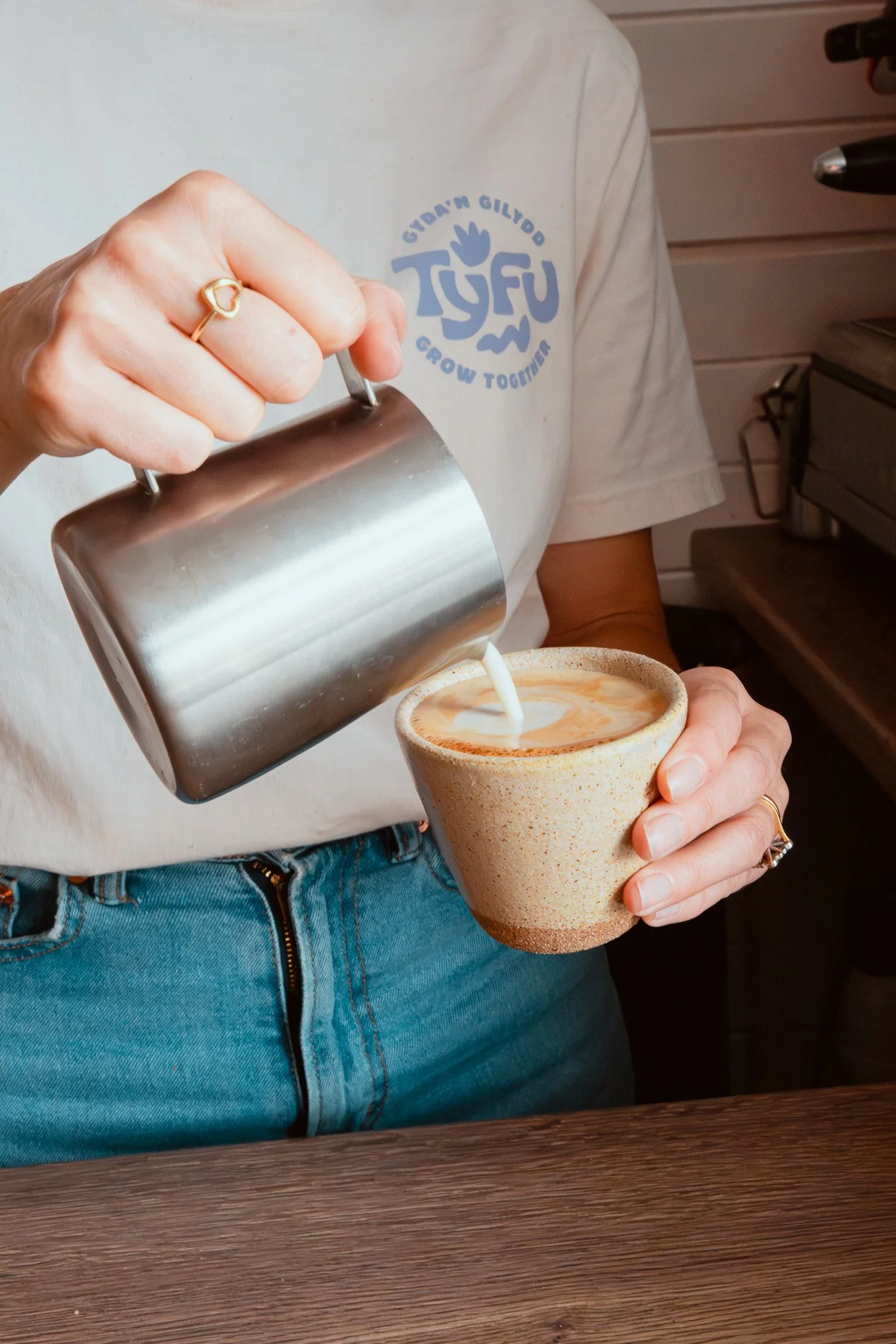 A hot Crafty Smuggler latte being poured into a handmade Matt Jones ceramic mug..