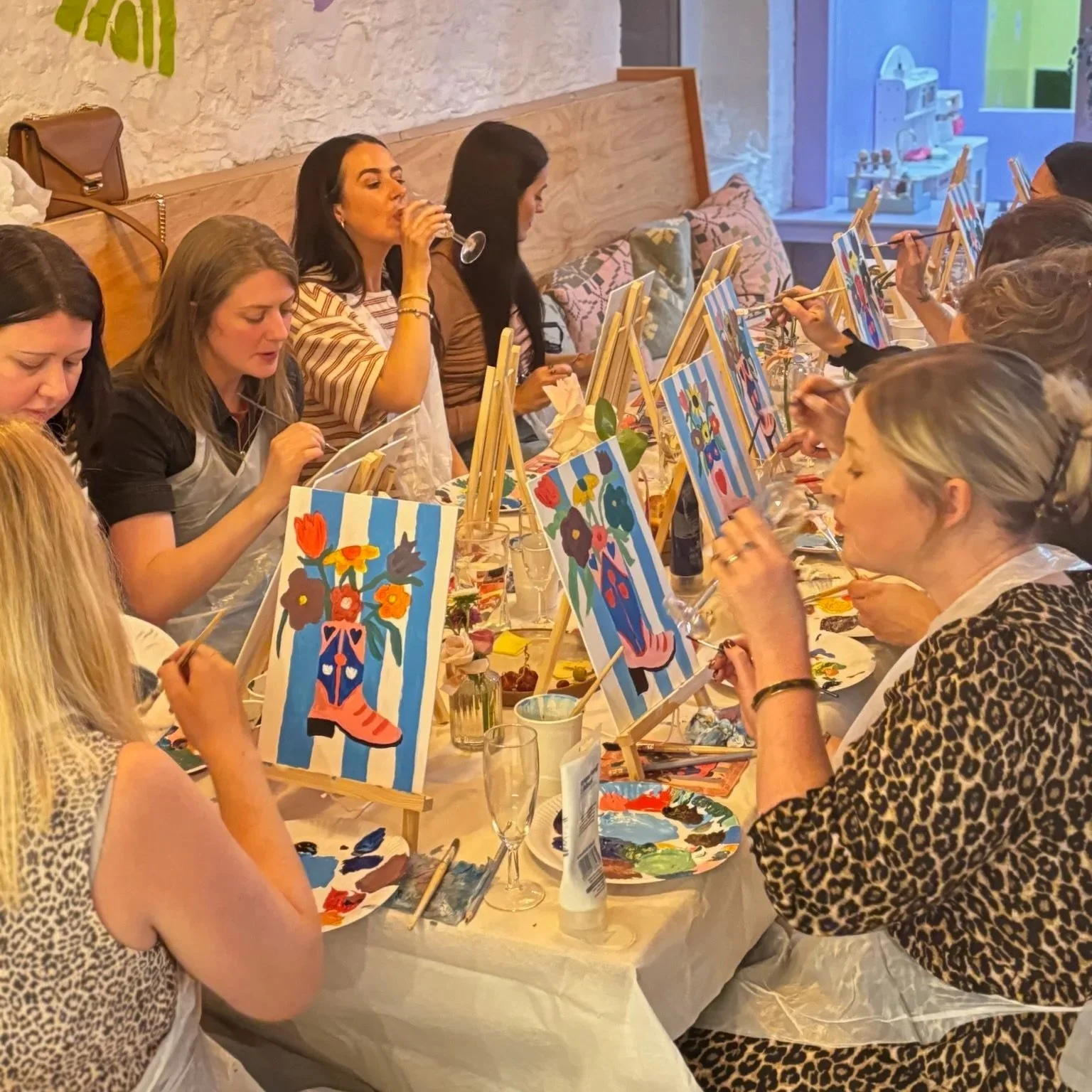 A group of ladies enjoying a sip and paint evening event