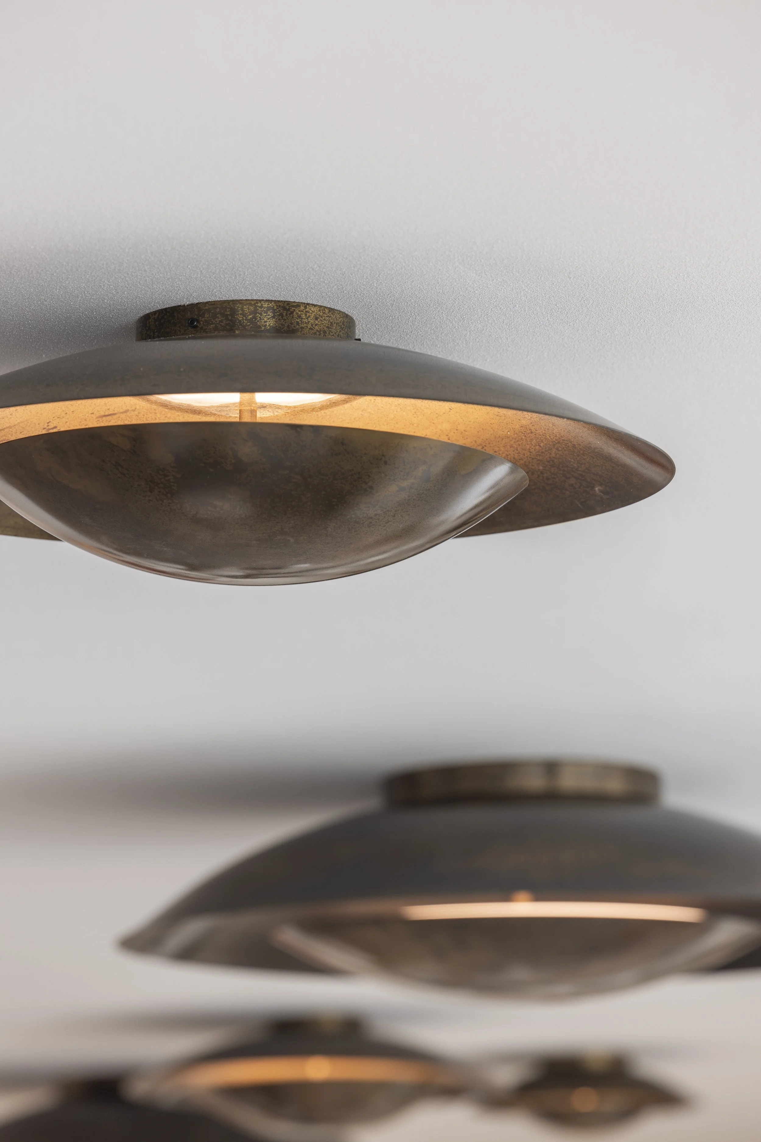 Close-up of ceiling lights with metal shades, viewed from below.