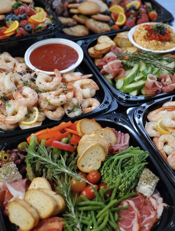 Assorted appetizer platters with shrimp, vegetables, cold cuts, fruit, bread, and dipping sauces.