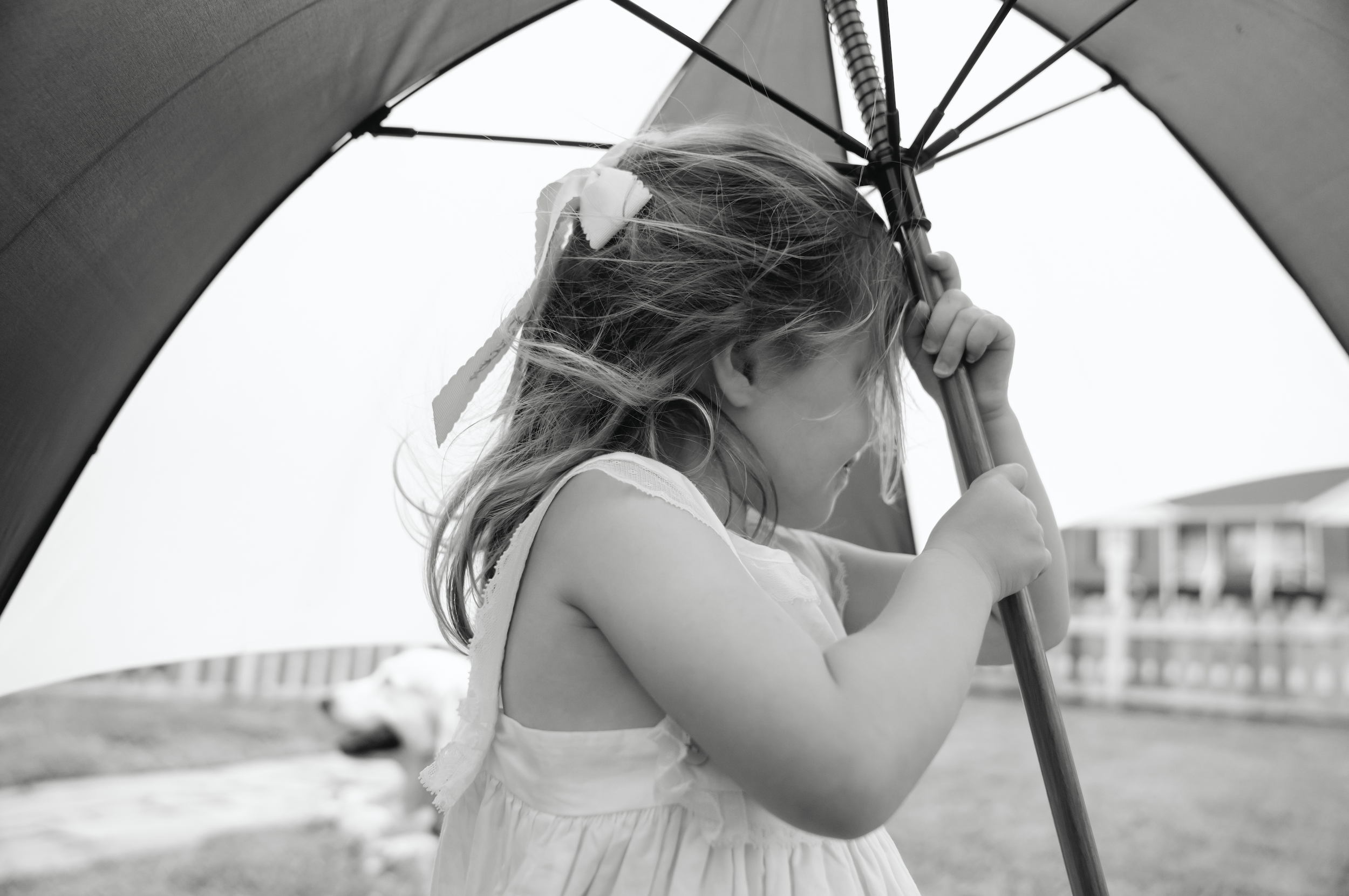 A young girl holding an umbrella on a cloudy day.