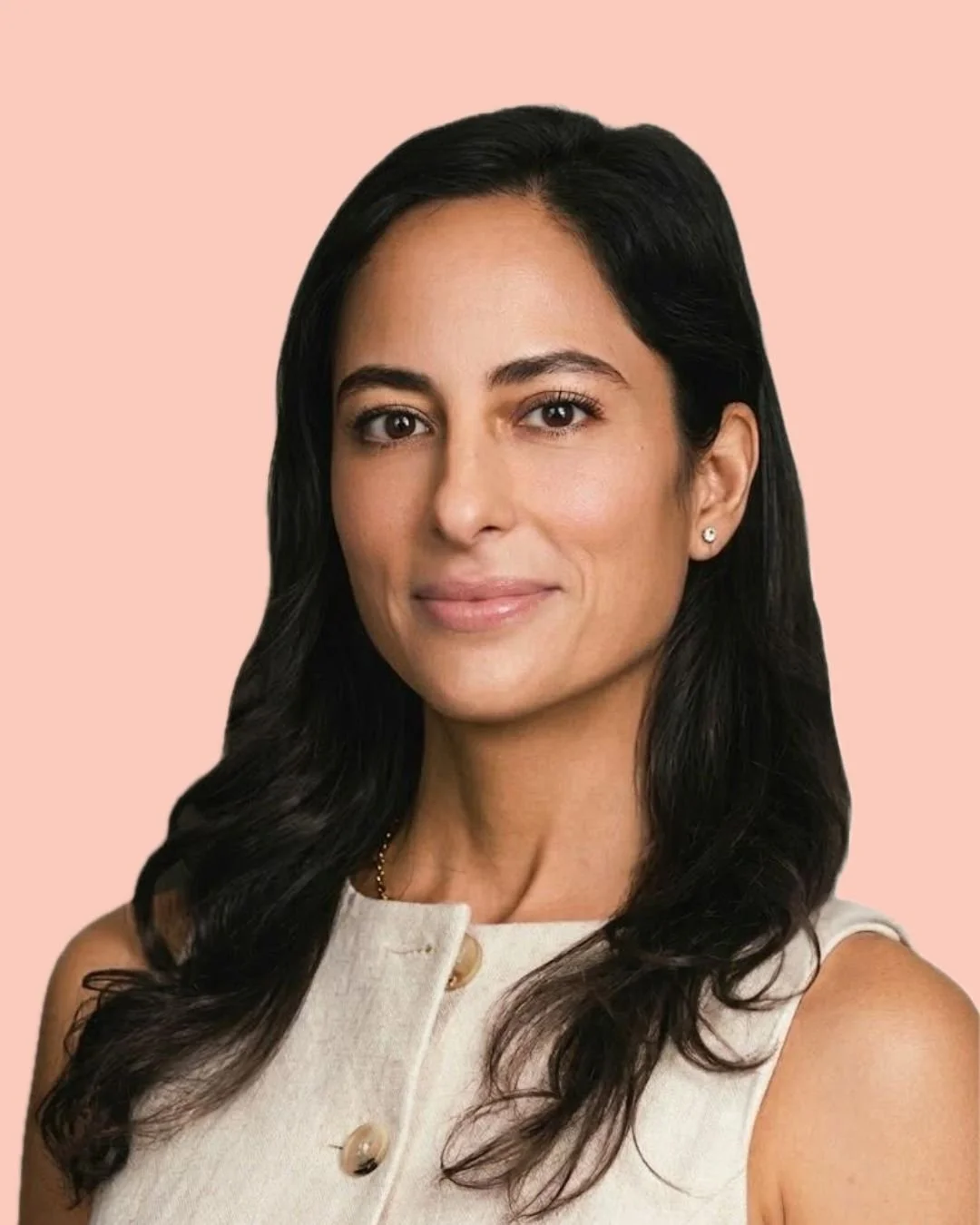 A woman with long dark hair, wearing a sleeveless cream-colored top with buttons, earrings, and a subtle smile, in front of a light orange background.