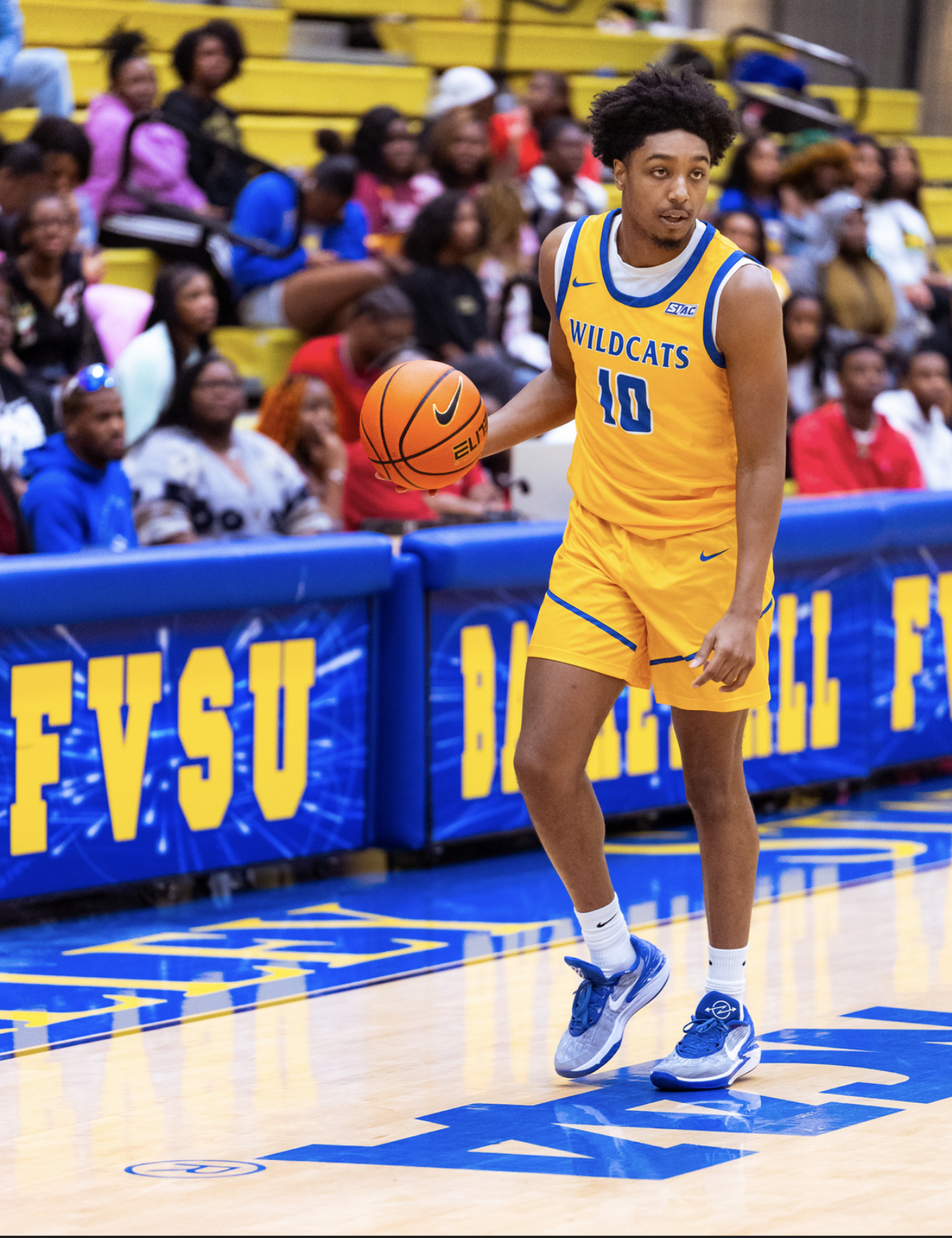 A basketball player in a yellow and blue uniform with 
