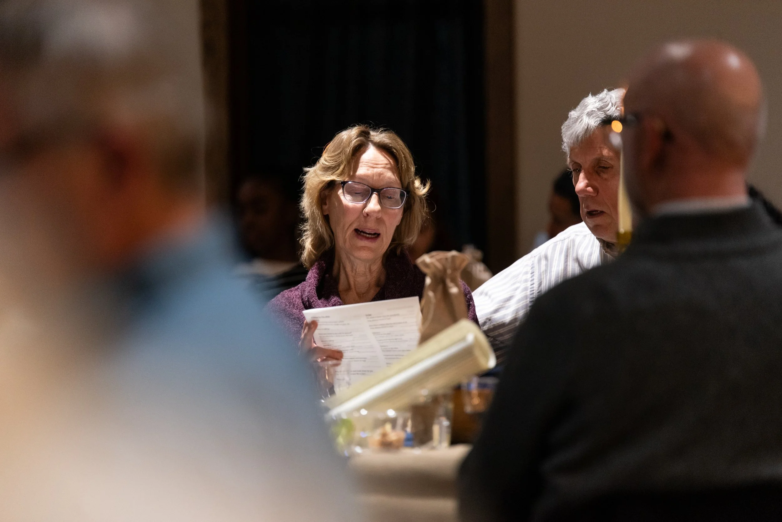 People seated at a table, engaged in conversation and reading menus in a restaurant setting.