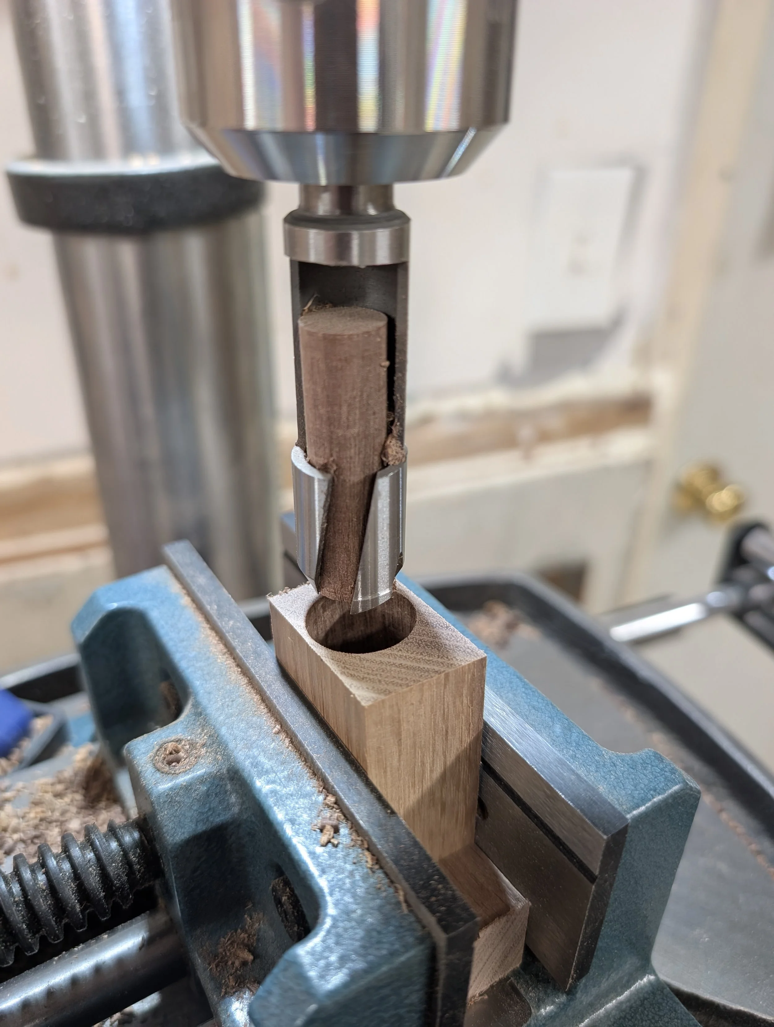 Drill press cutting out a walnut plug