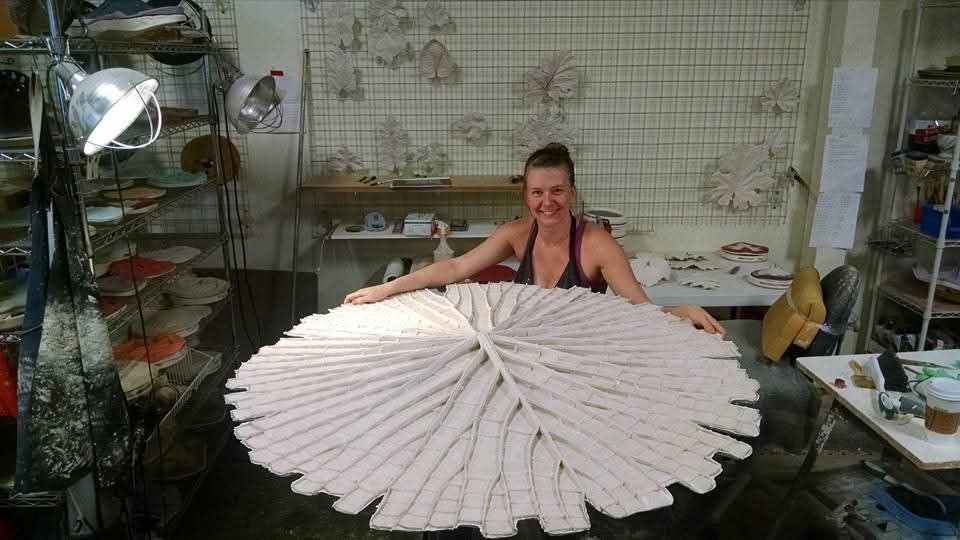 Tania McCamy in her studio displays a large, white in process sculpture of the impressions of a giant water lily leaf.