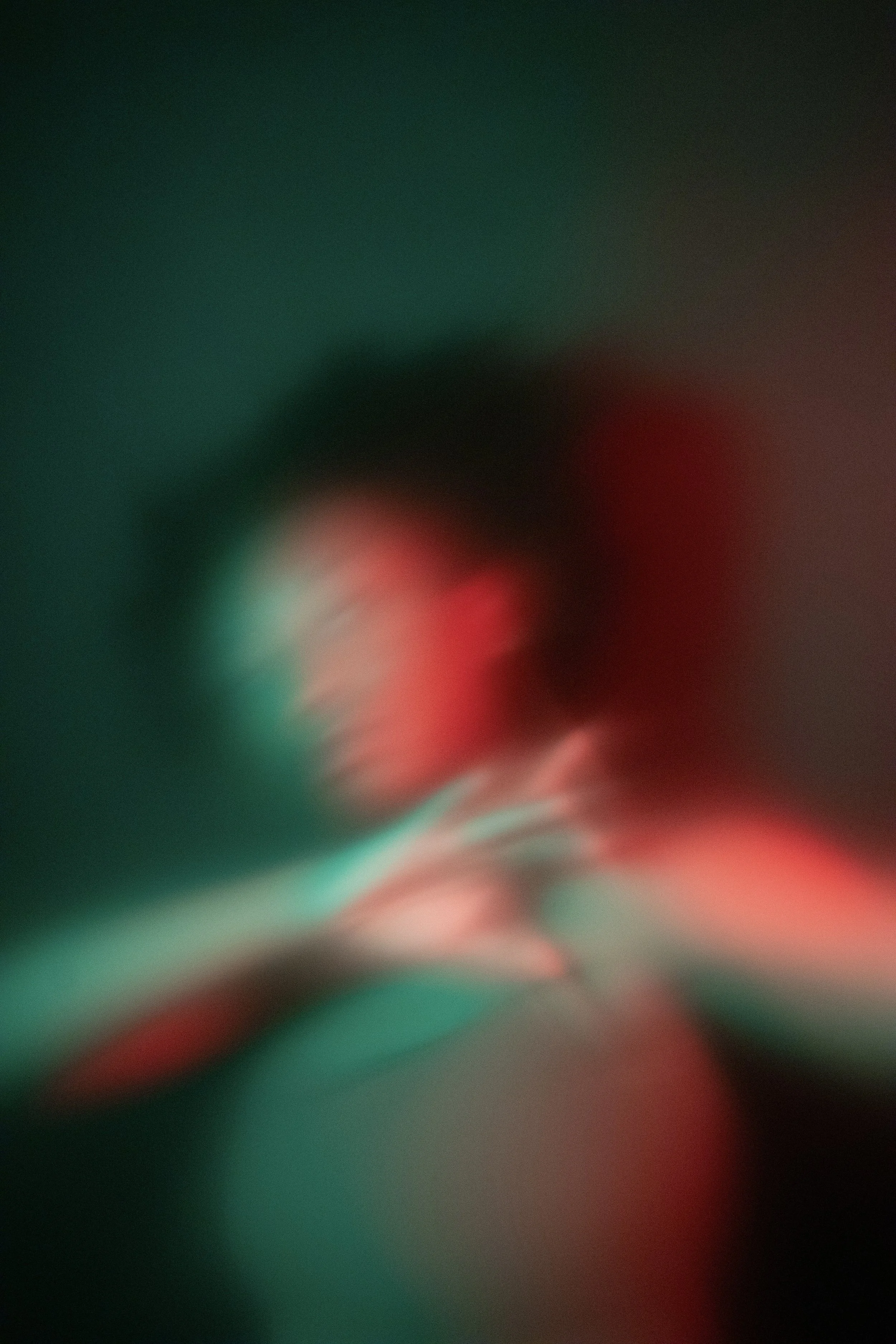 Blurred abstract image with red, green, and black colors.