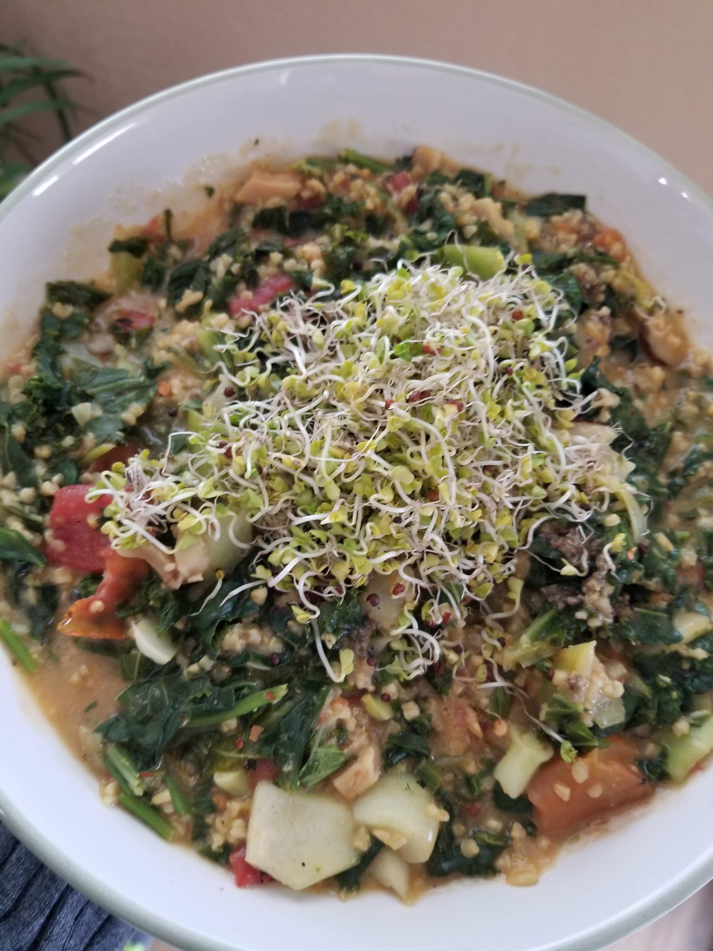 Savory Oats made with whole-food, plant-based, gluten-free ingredients, topped with fresh vegetables, sprouts, and herbs for a hearty, nourishing breakfast.