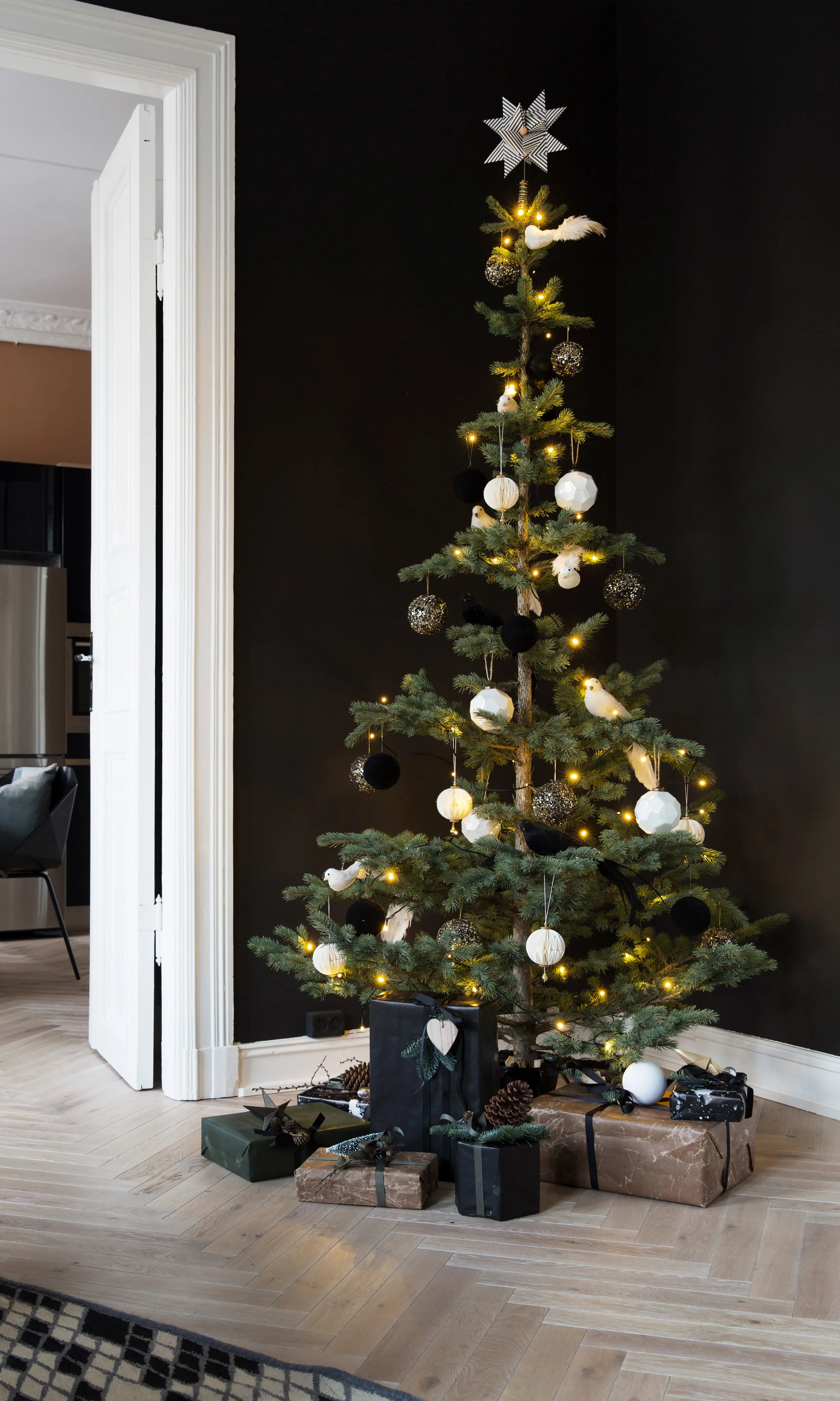 Juletreet er en slank edelgran kjøpt inn på St. Hanshaugen. Pynten er fra Milla Boutique, kulene har grafiske fordypninger og de svarte og hvite fuglene gir det hele et lekent uttrykk.
