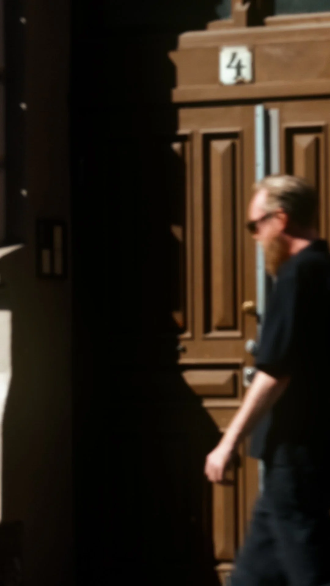 Per Ove Akselvoll wearing HUG Spectacles DUPREE sunglasses while walking through a sunlit Oslo street.