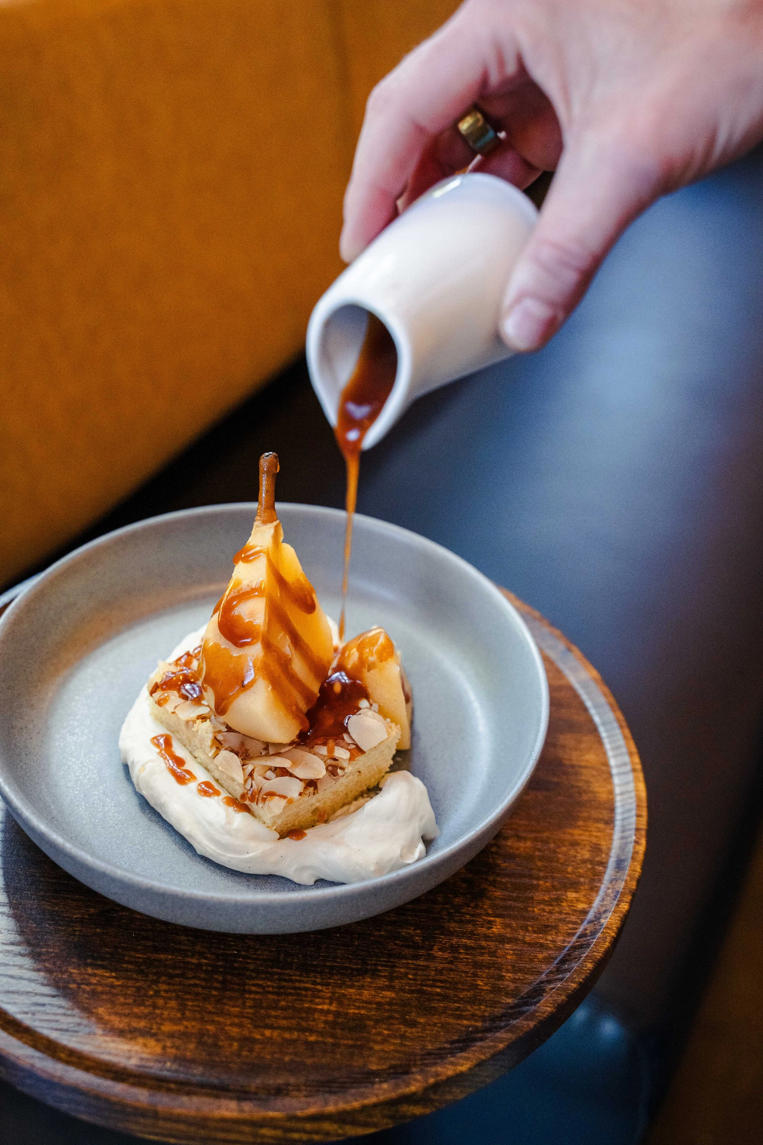 Brandy brown butter poached pear with frangipane cake, toasted almonds, housemade whipped cream, and warm cinnamon caramel at Eddy’s Kitchen in downtown Aspen.