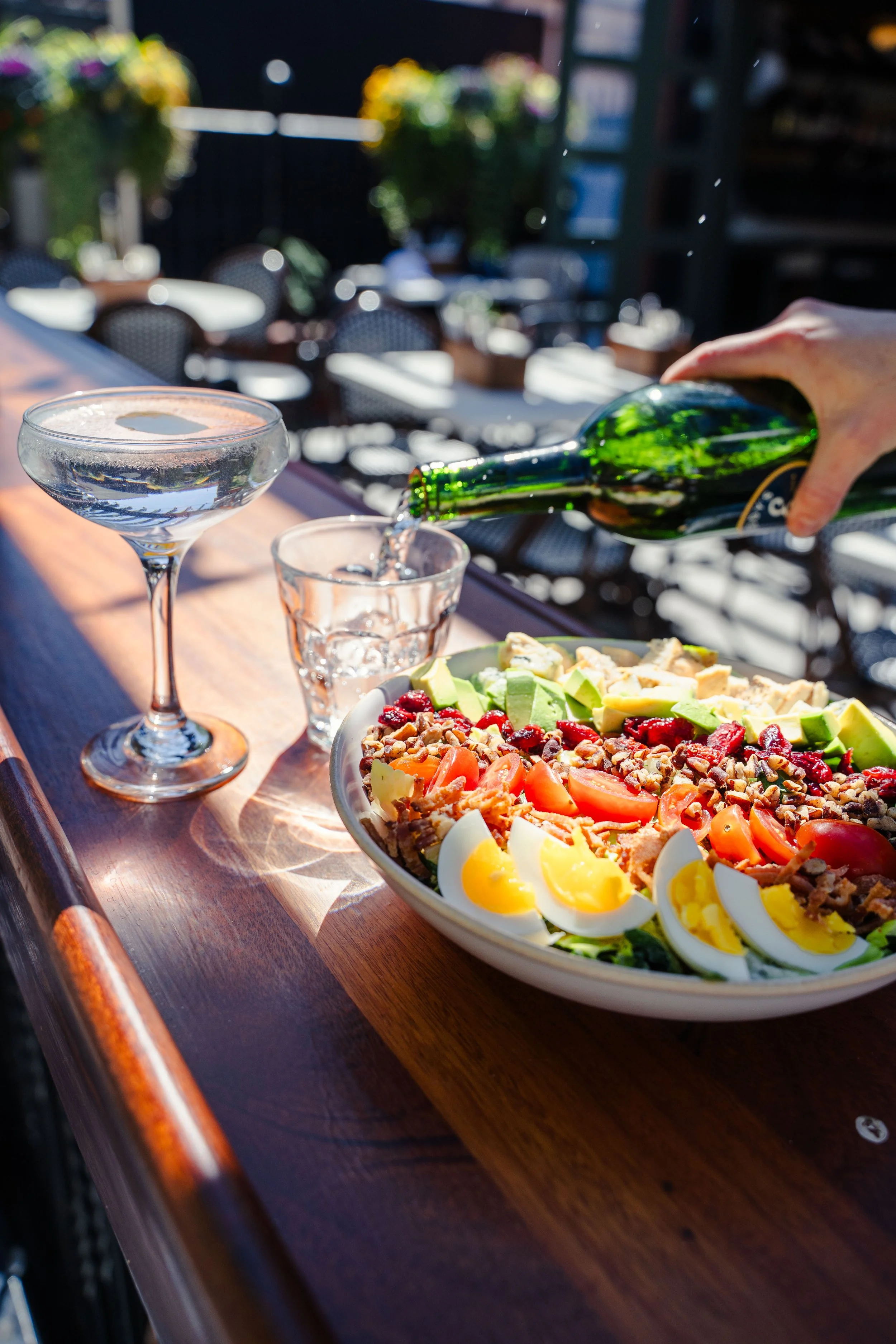 Classic Cobb salad paired with an ice-cold martini at Eddy’s Kitchen’s outdoor bar, perfect for casual patio dining in downtown Aspen.