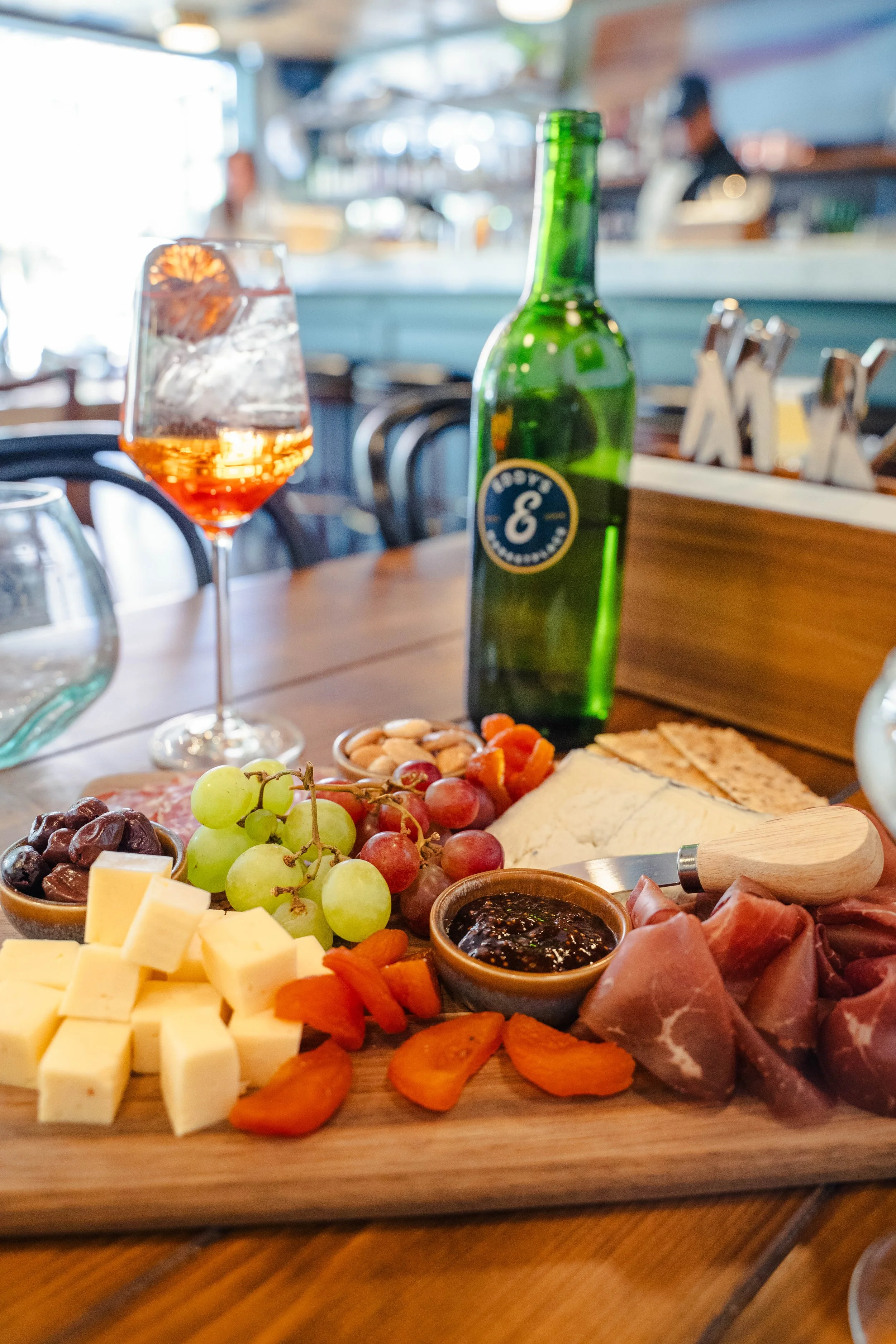 Charcuterie board with gourmet cheeses and a refreshing spritz inside Eddy’s cozy, casual restaurant in downtown Aspen.