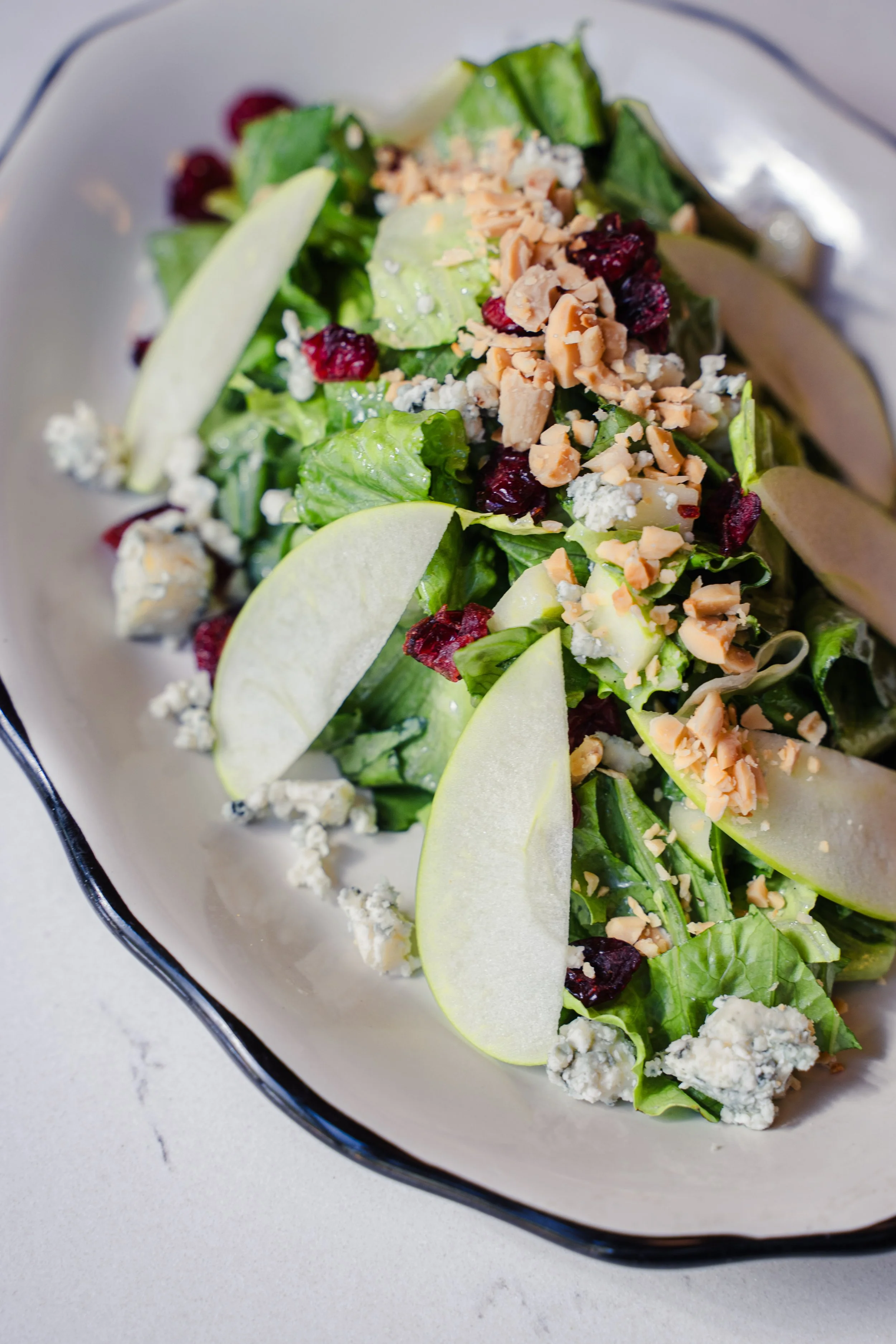 The Eddy salad with chopped romaine, Gorgonzola, Granny Smith apples, buttery Marcona almonds, and dried cranberries tossed in housemade vanilla white balsamic vinaigrette at Eddy’s Kitchen in downtown Aspen.