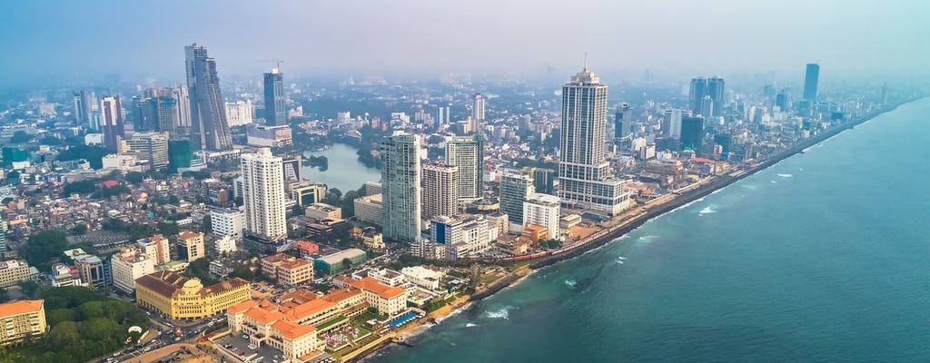 Aerial view of a city skyline along the coast with high-rise buildings and a shoreline beach.