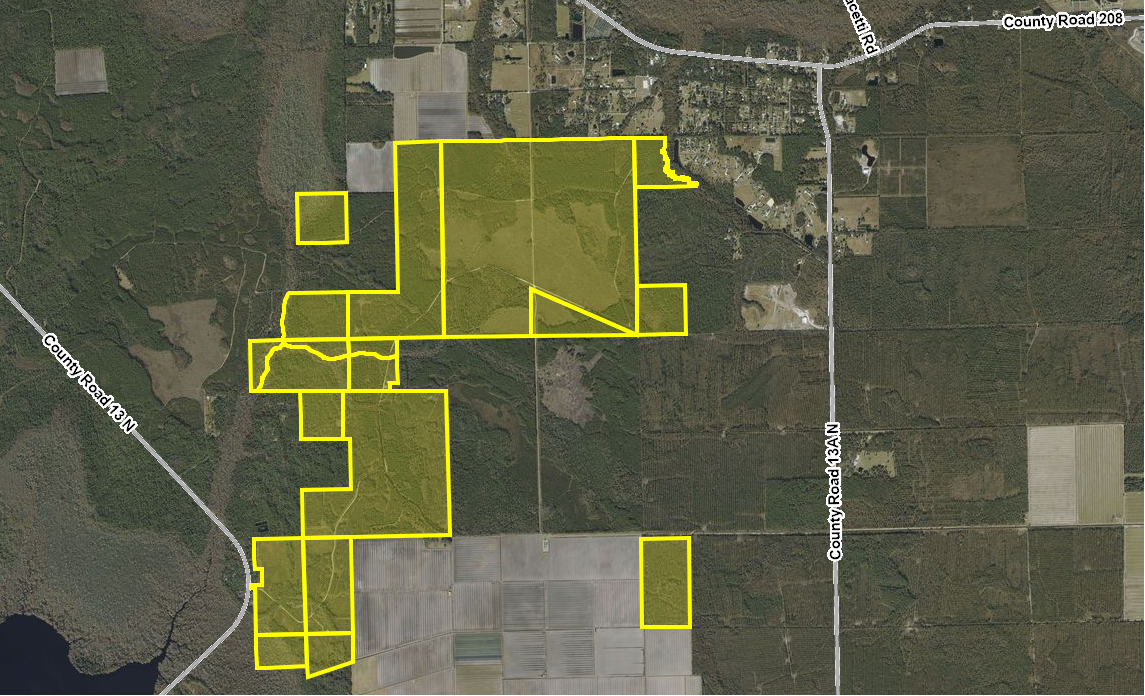 A satellite map showing a large area of parcels outlined in yellow, located near County Roads 13 NW and 208 in a rural area with forests, fields, and some buildings.