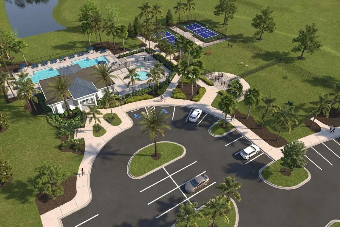 An aerial view of a community recreational area with a swimming pool, a hot tub, tennis courts, and a parking lot surrounded by landscaped greenery and palm trees.