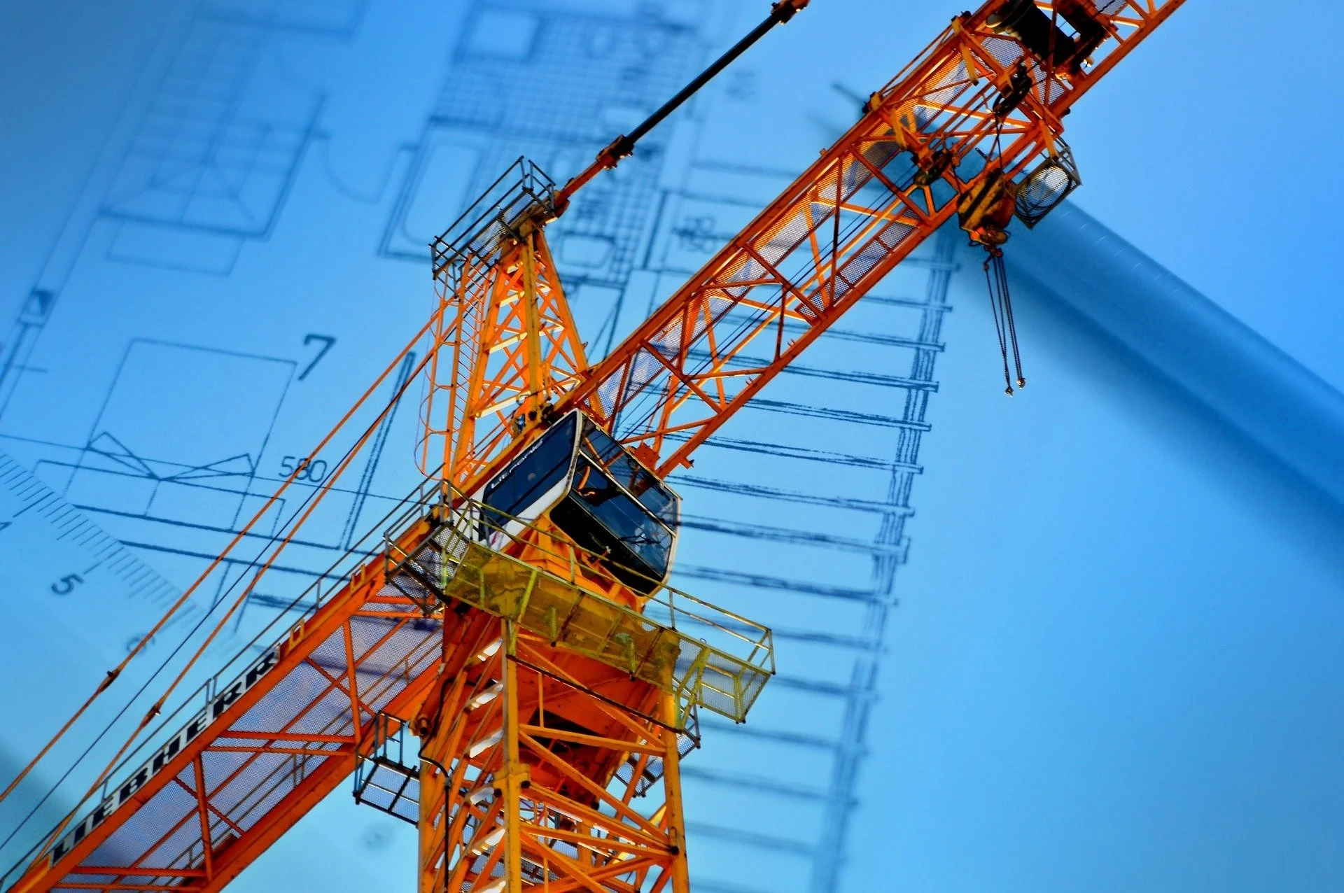 A tall orange construction crane against a blue sky with faint technical drawings overlaid.