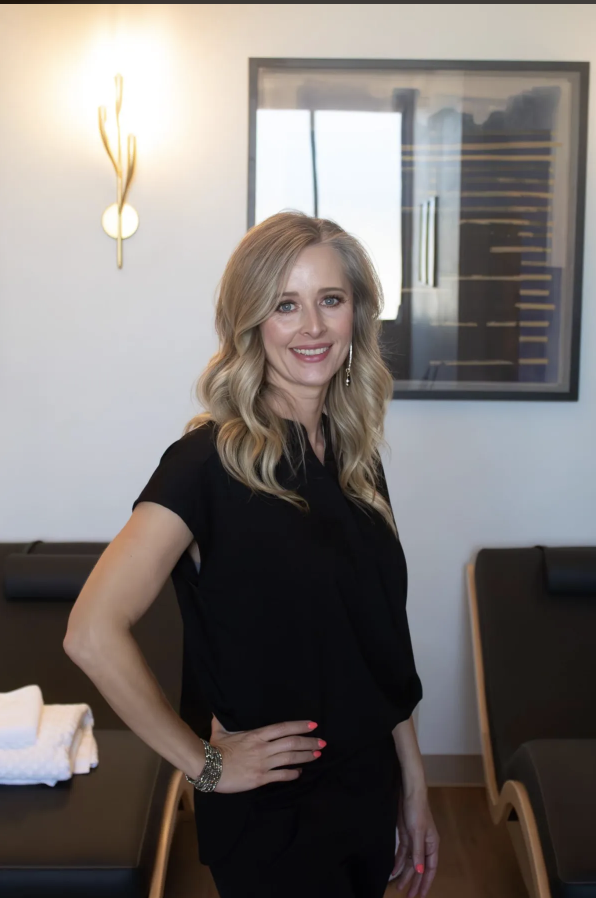 blonde woman with black scrubs smiling