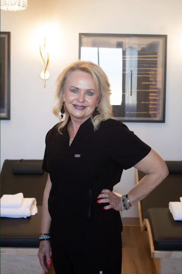blonde woman with black scrubs smiling