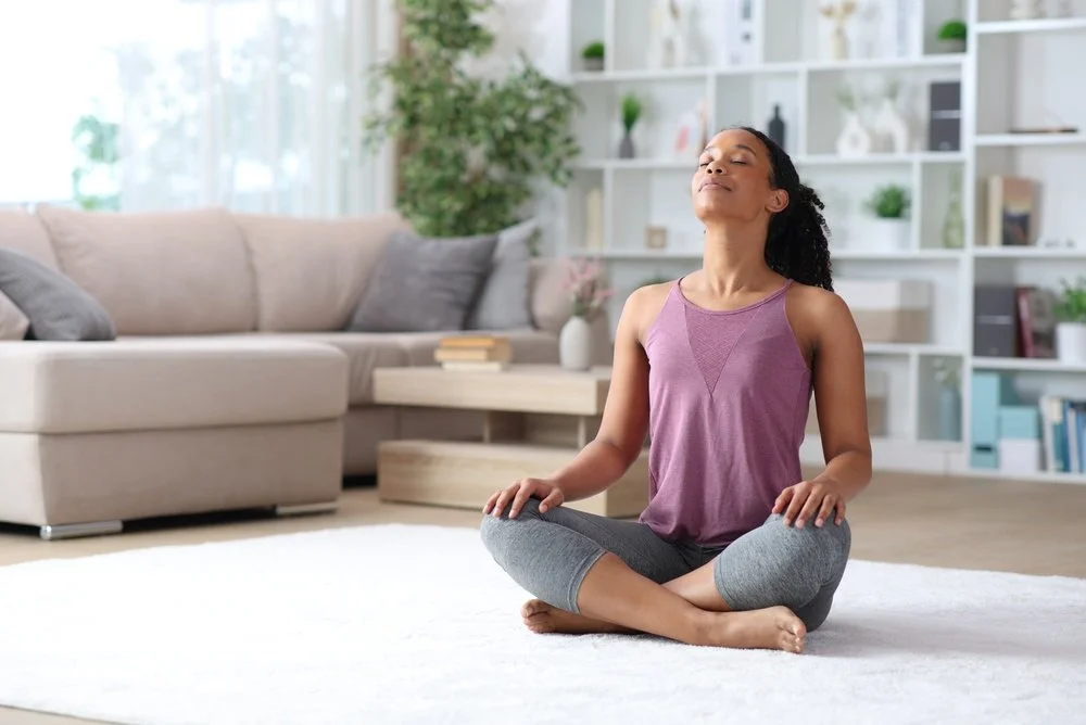 Woman practicing meditation in a living room