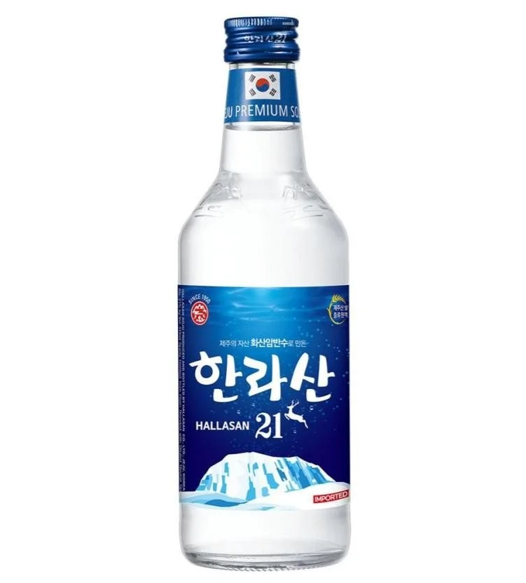 A clear glass bottle of Korean soju with a blue label depicting an ice mountain and Korean characters, with a blue cap showing the South Korean flag.