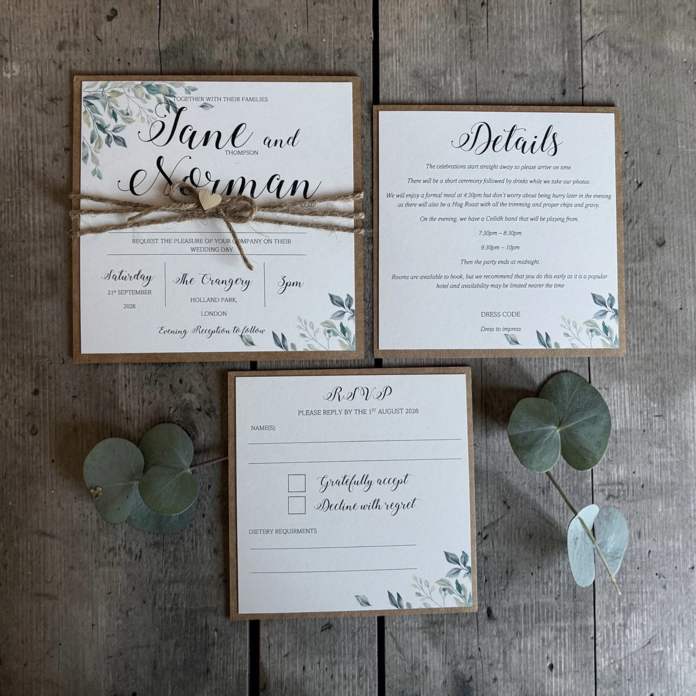 Two wedding programs on a wooden surface, decorated with greenery and a tied twine with a heart tag on the first program.