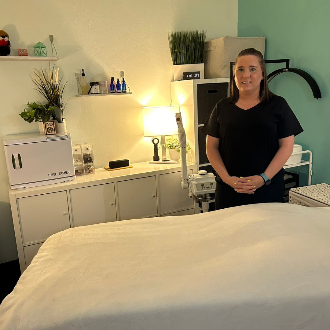 Dana standing beside the treatment table inside DK Spa in Lynnwood