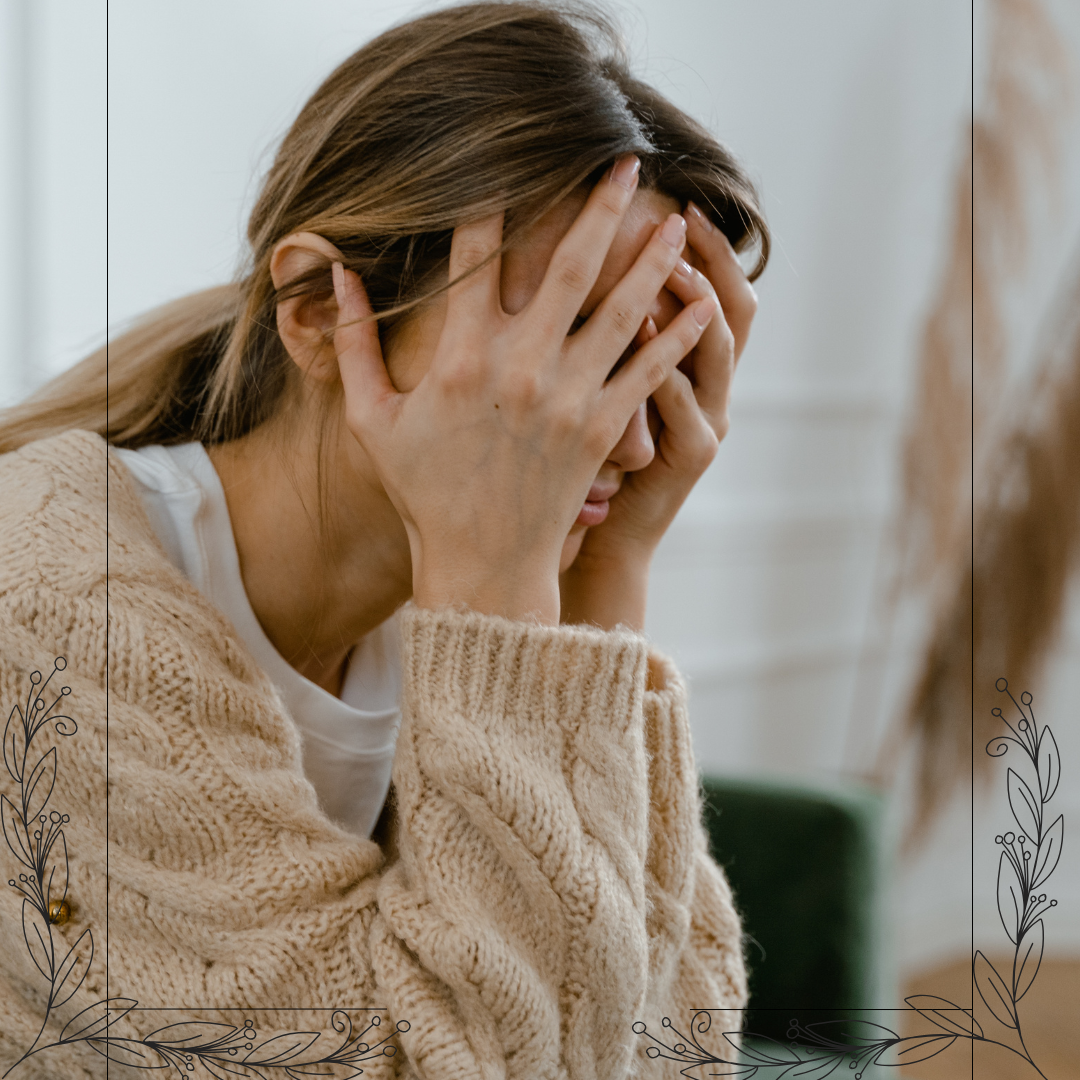 Woman sitting with her hands over her face during a stressful moment