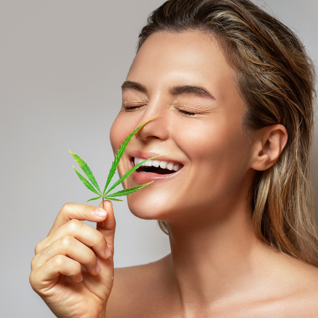 Woman holding a hemp leaf as a visual representation of CBD wellness